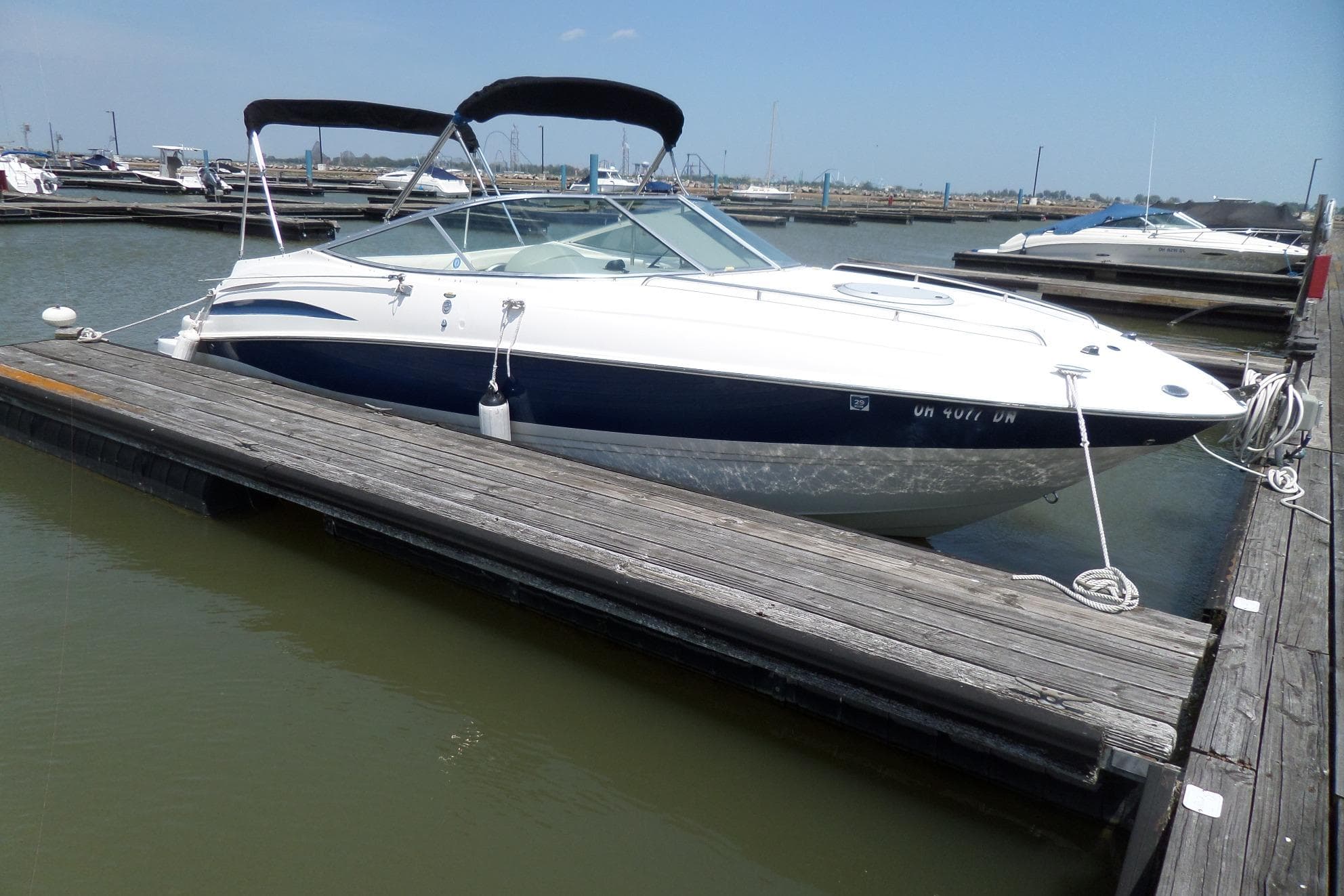 2003 Maxum 2400 SC boat docked at marina on a sunny day.