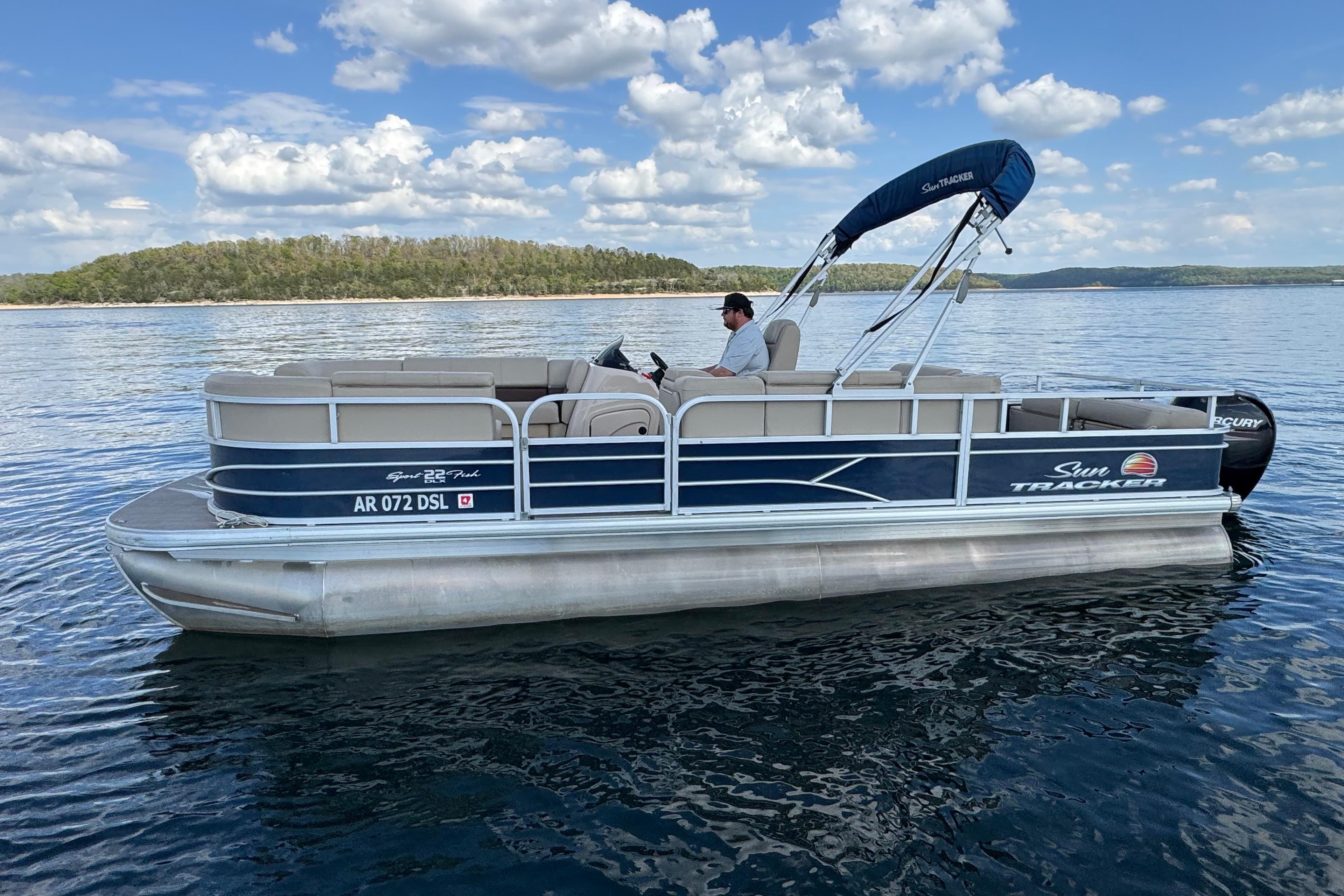 2019 Sun Tracker Party Barge 22 Sport Fish pontoon boat on a serene lake.