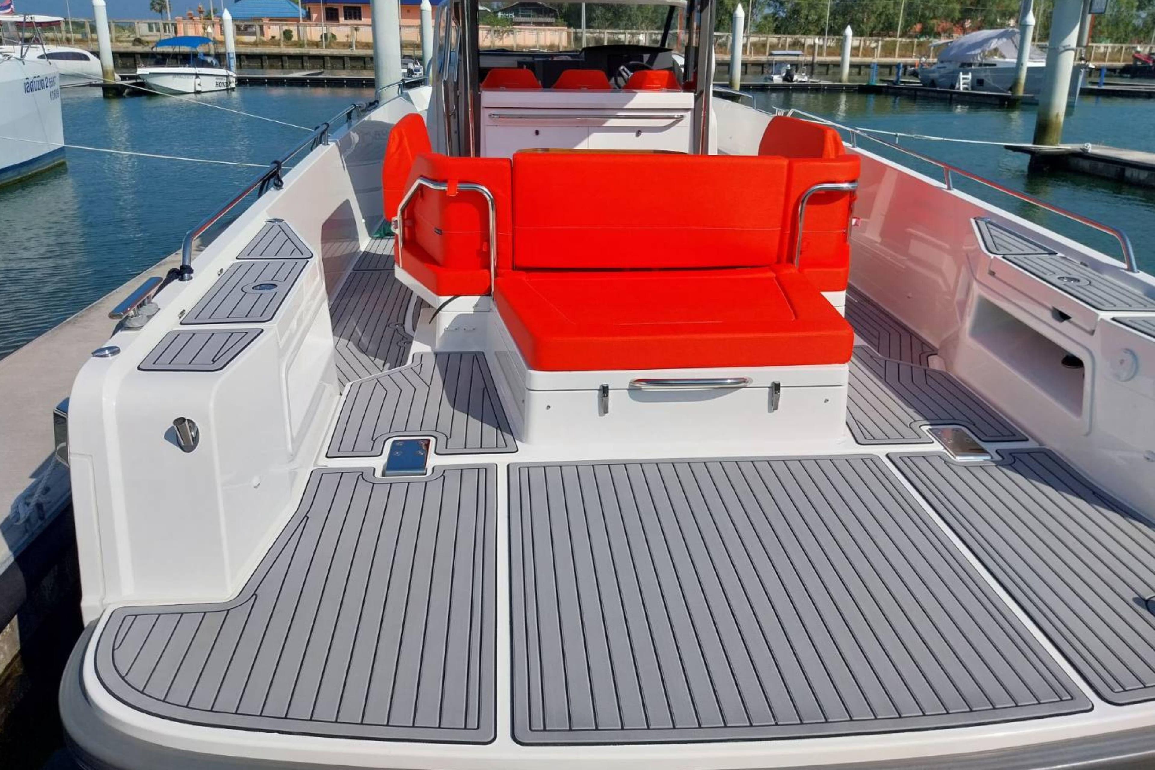 2023 Nimbus T11 boat with red seating and sleek deck design at a marina.