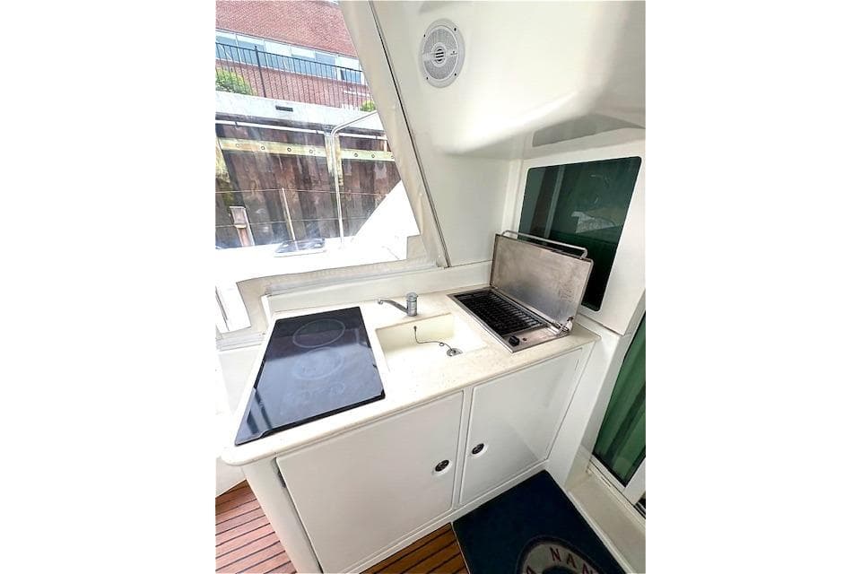 Compact kitchen area on a 2008 Lagoon 440 yacht with stove and sink.