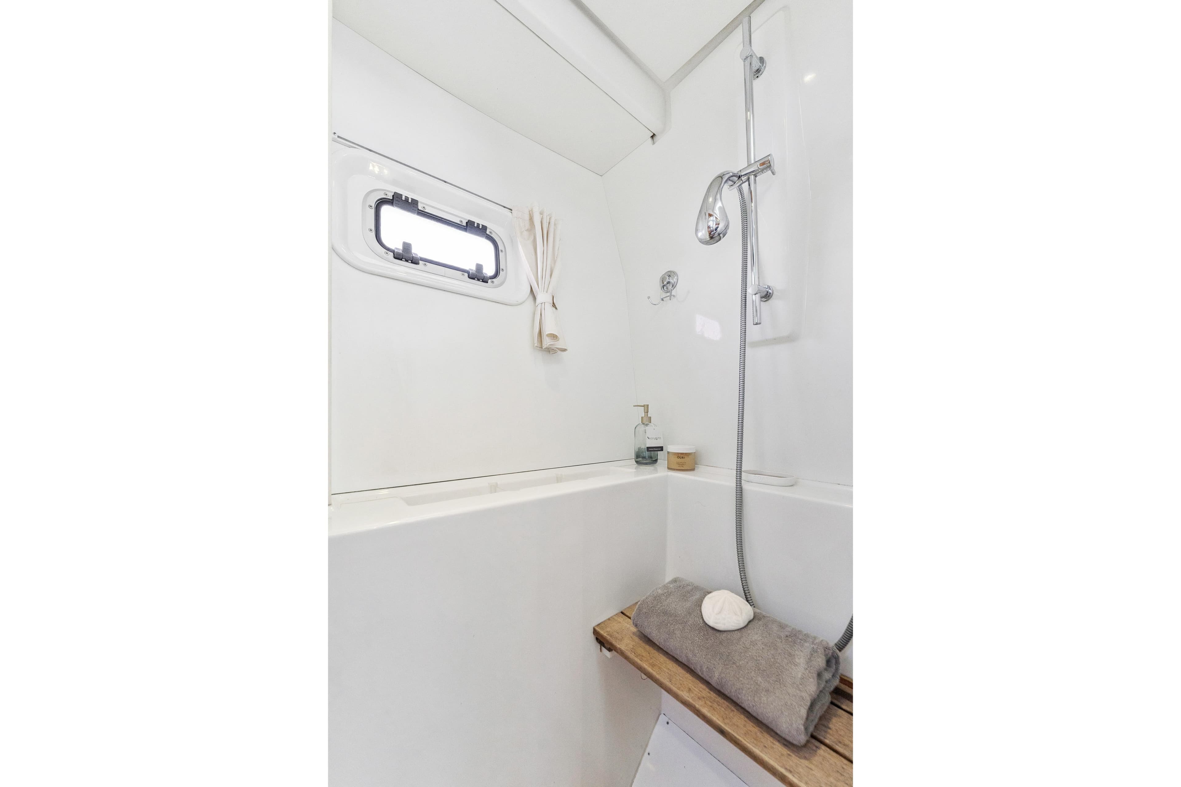 Luxurious bathroom in 2012 Lagoon 560 yacht with shower and porthole window.