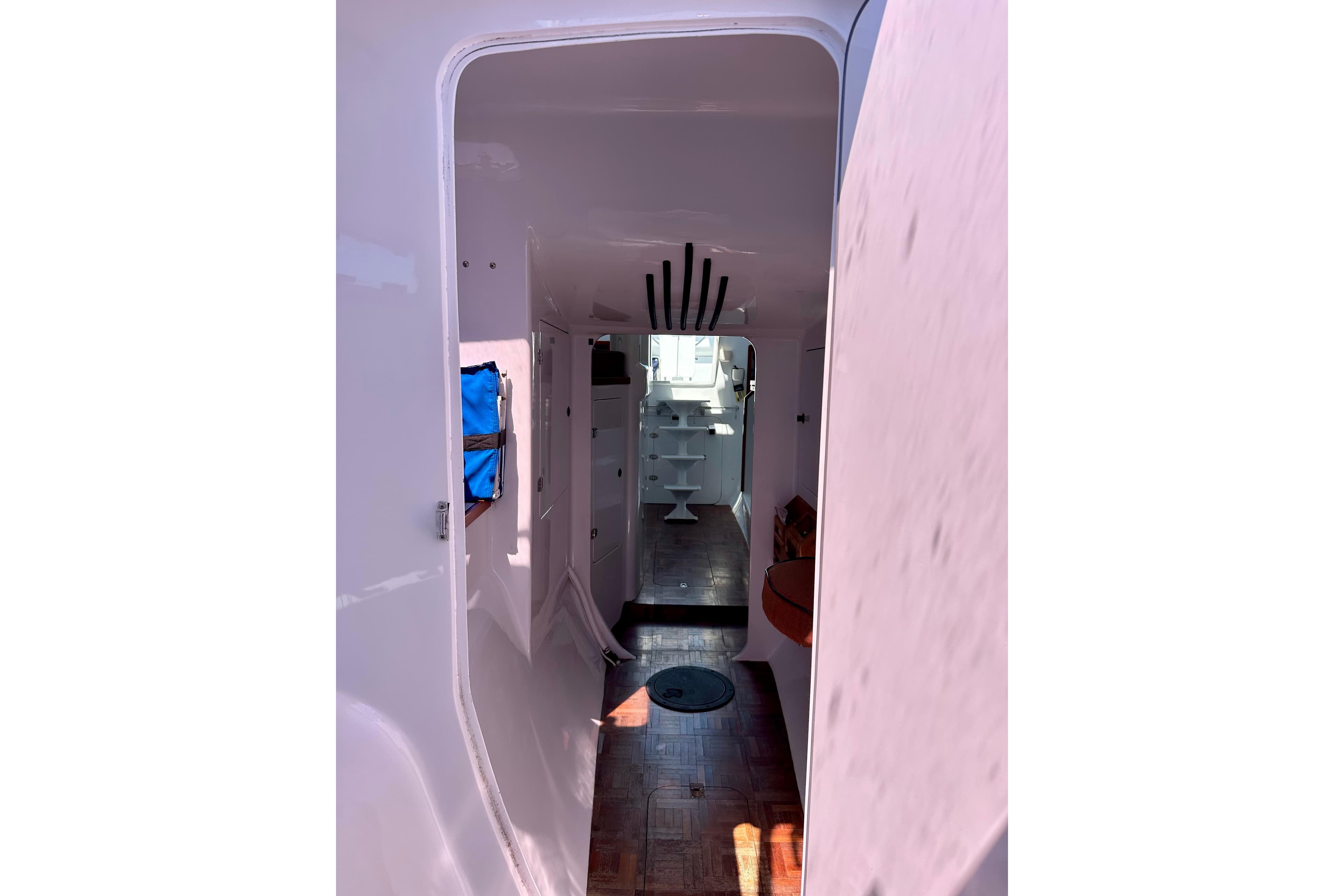 Interior view of 2012 Hughes 40 sailboat, featuring sleek white design and wooden flooring.