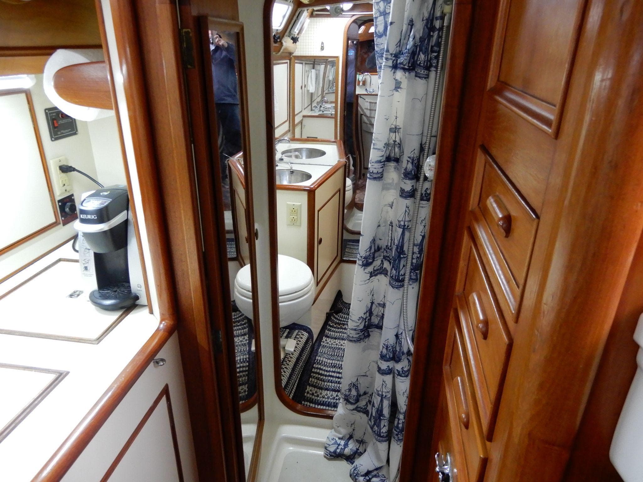 1985 Barnett Offshore yacht interior with wooden cabinetry, compact kitchen, and nautical-themed bathroom.