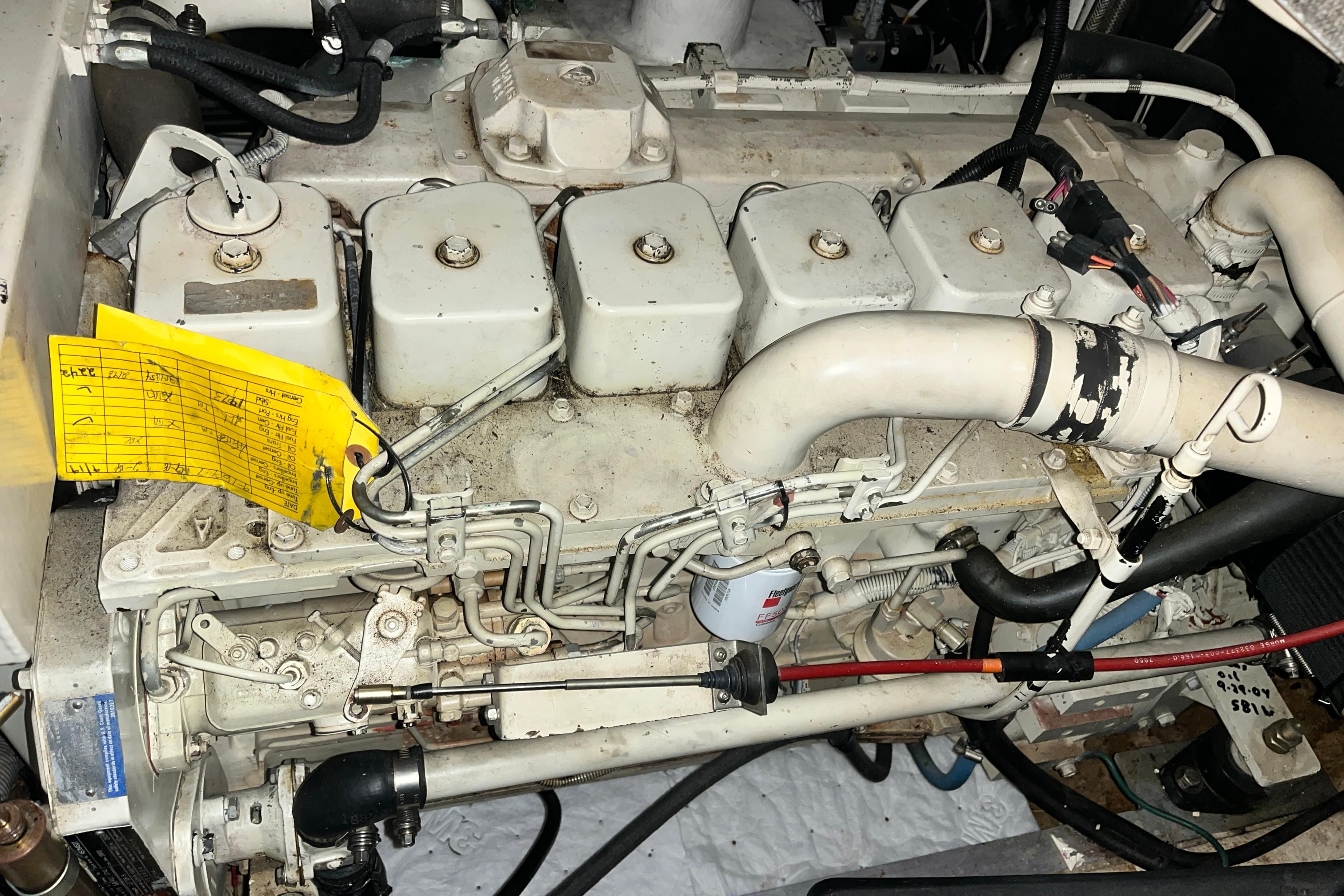 Engine of a 1999 Nordic Tug 32 boat with maintenance tag attached.
