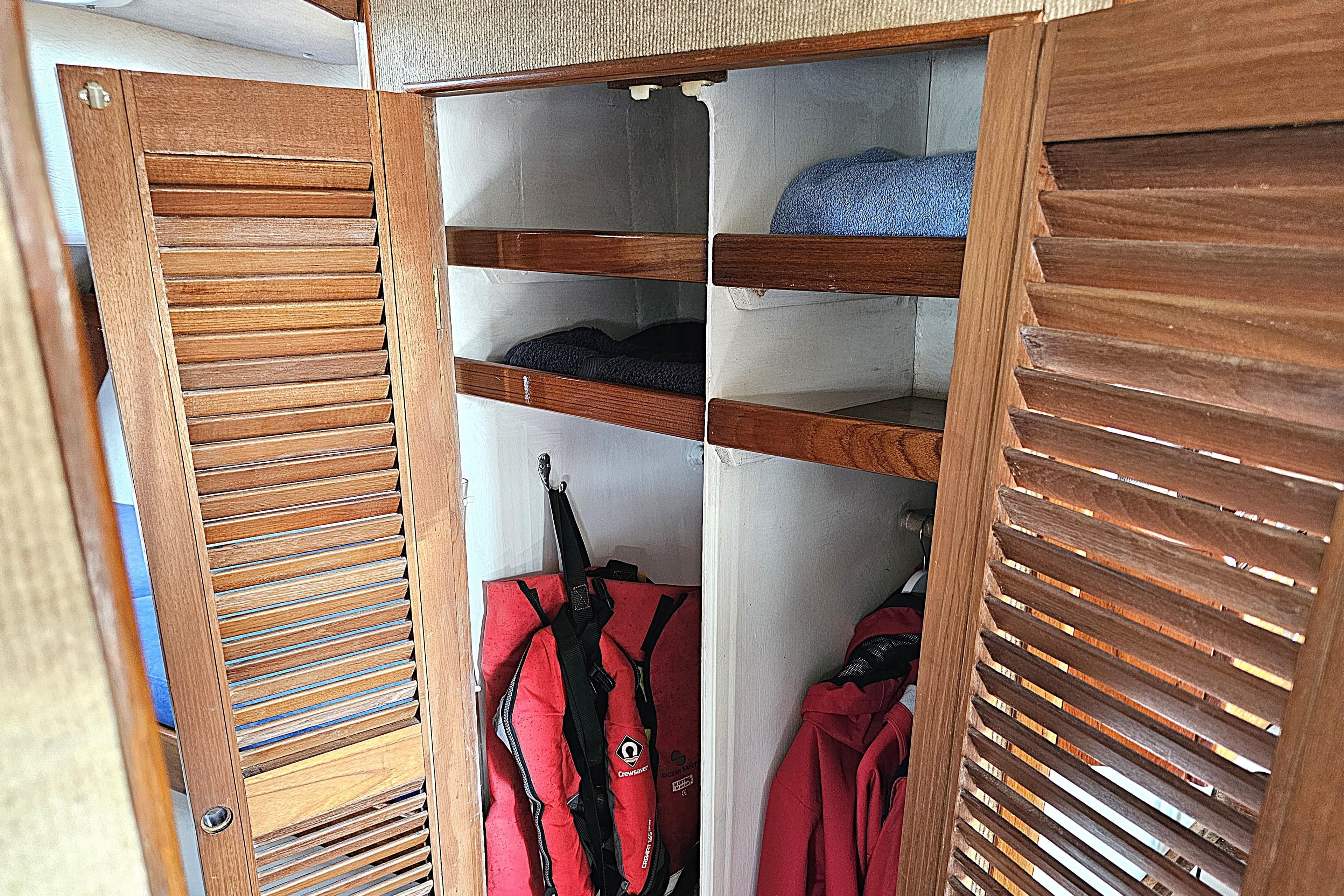 Wooden closet with shelves and life jackets on a 1974 Fairways Marine Fisher 30 boat.