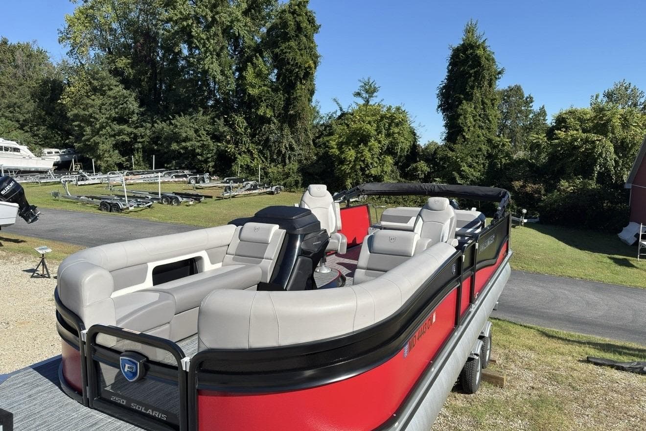 2024 Premier 250 Solaris pontoon boat with red exterior and spacious seating.