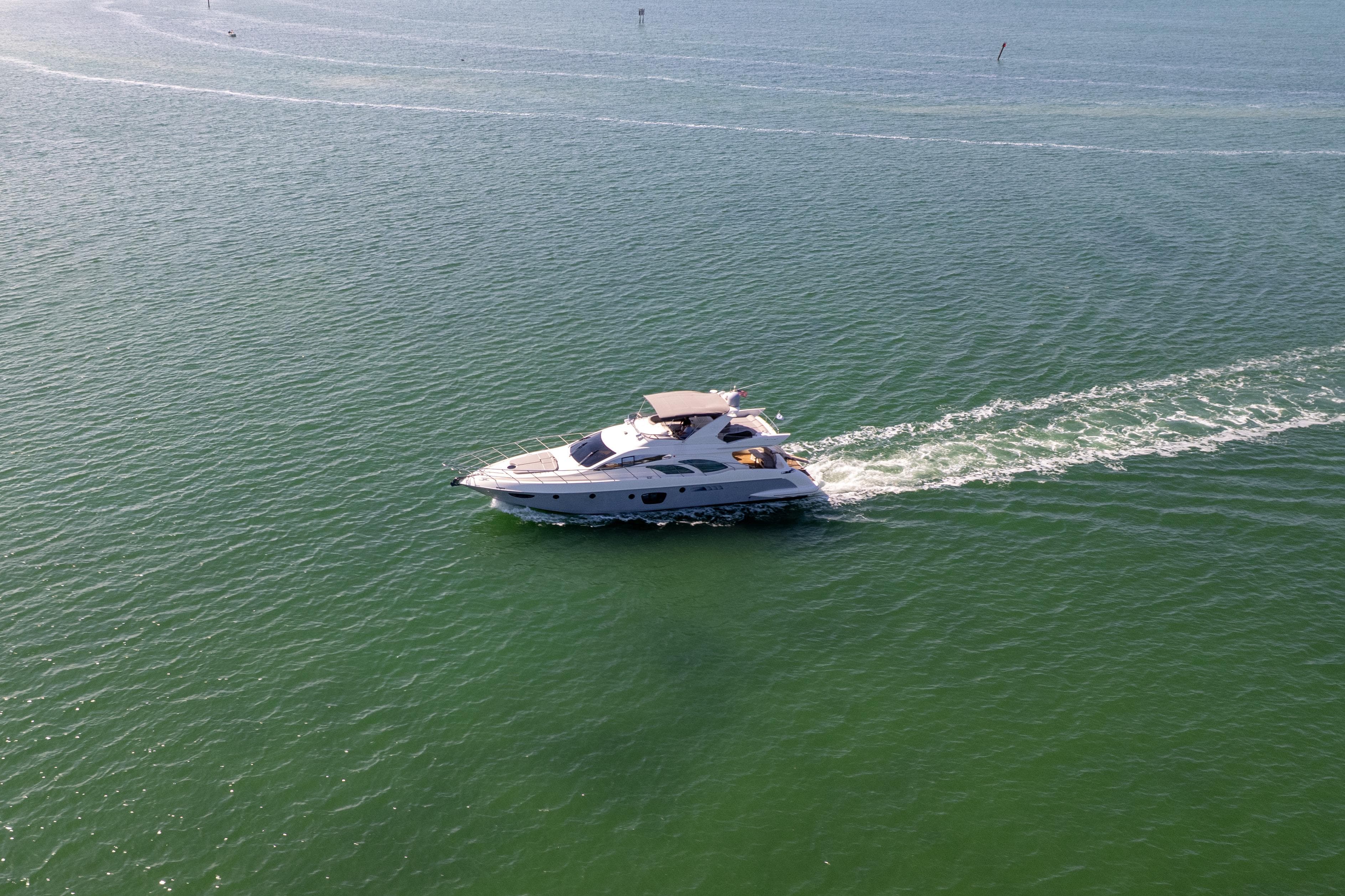2008 Azimut 62E yacht cruising on open water, leaving a gentle wake.