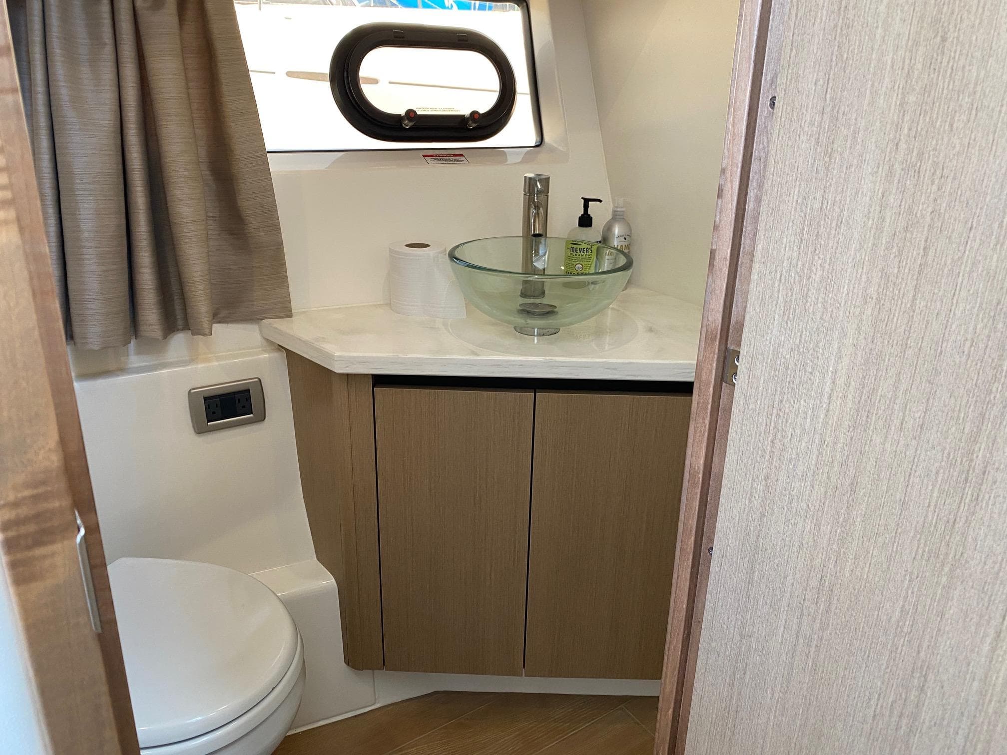 2018 Sea Ray 400 Fly bathroom with modern sink and wooden cabinetry.