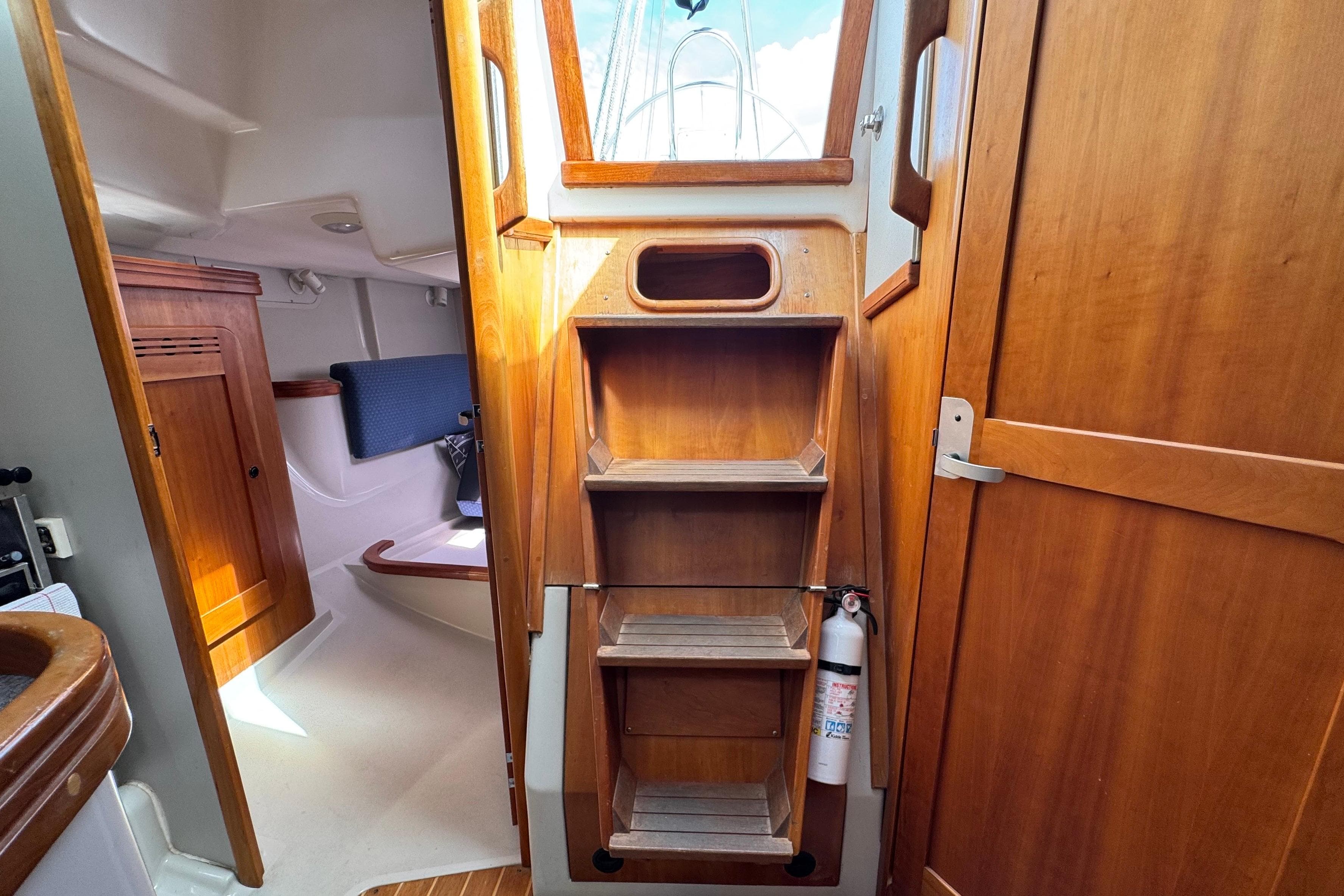Interior of 2004 C&C 110 sailboat with wooden cabinetry and steps.