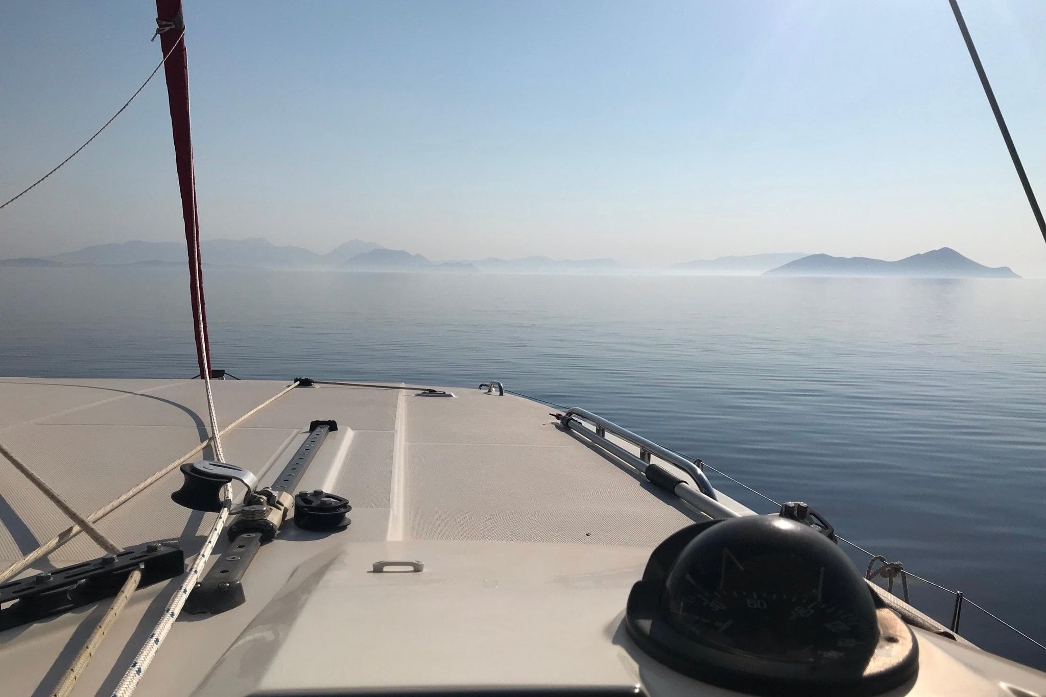 Lagoon 46 catamaran sailing on calm sea with distant islands, 2020 model.