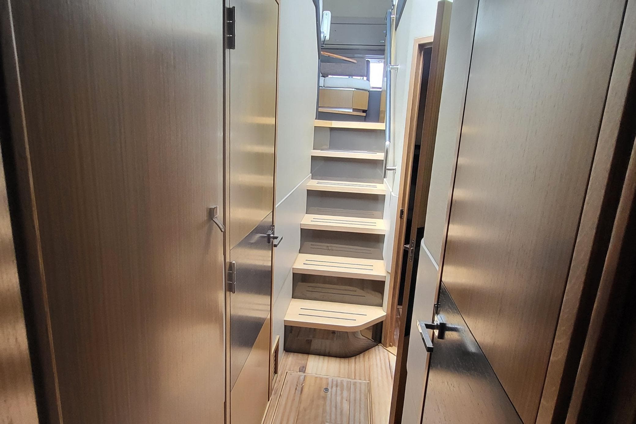 Interior hallway of 2018 Sea Ray L590 Fly yacht with wooden stairs and doors.