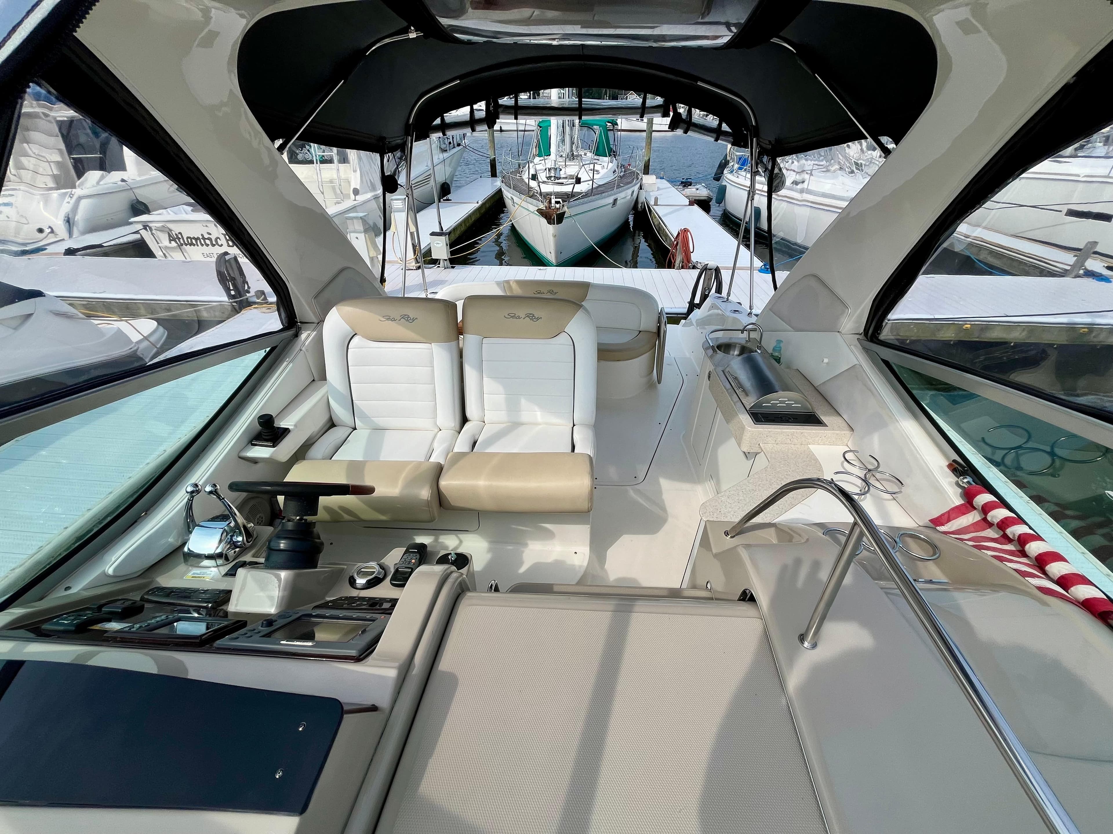 2009 Sea Ray 310 Sundancer interior with helm, seating, and marina view.