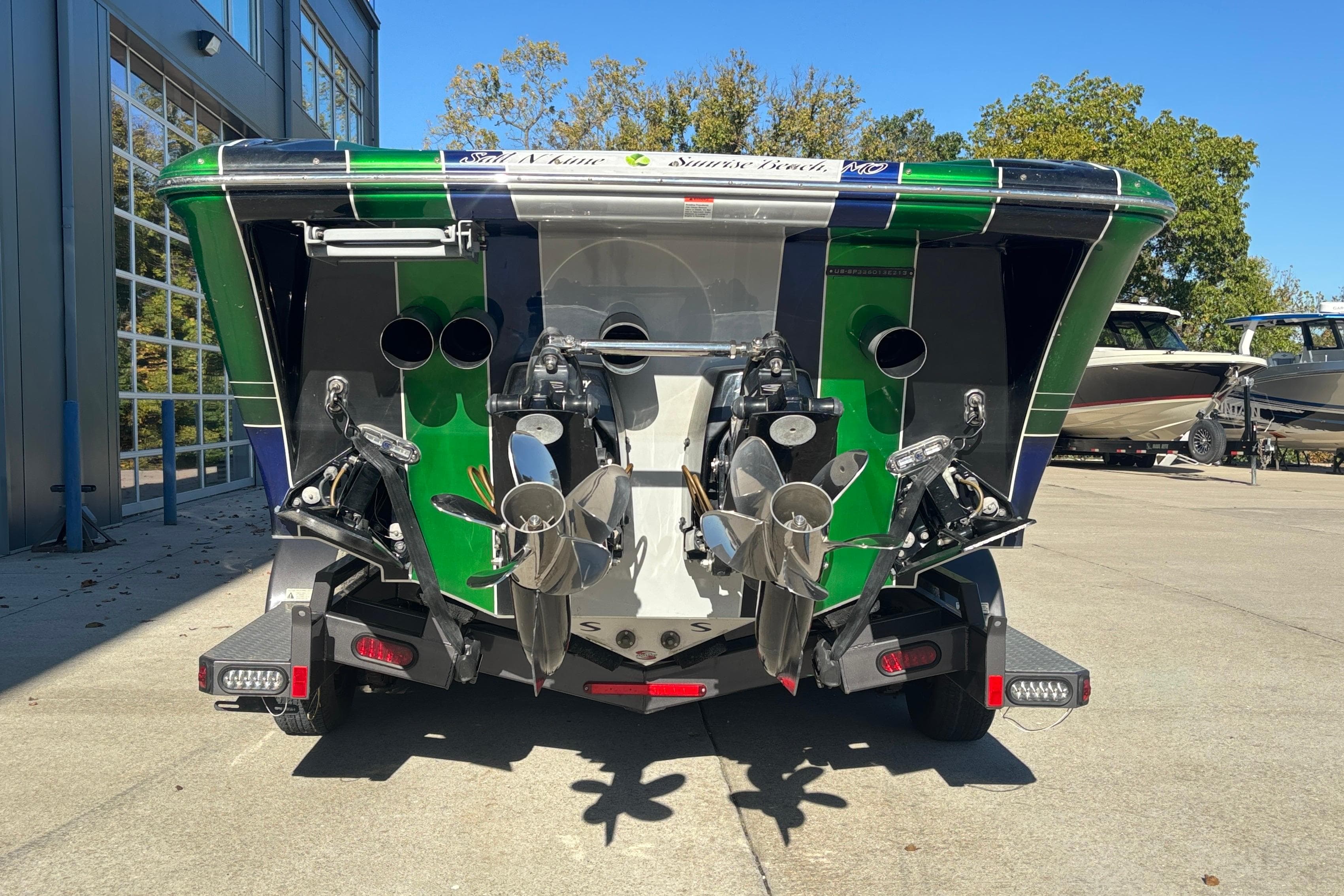 Rear view of 2013 Sunsation 36 XRT boat with dual propellers and vibrant green accents.