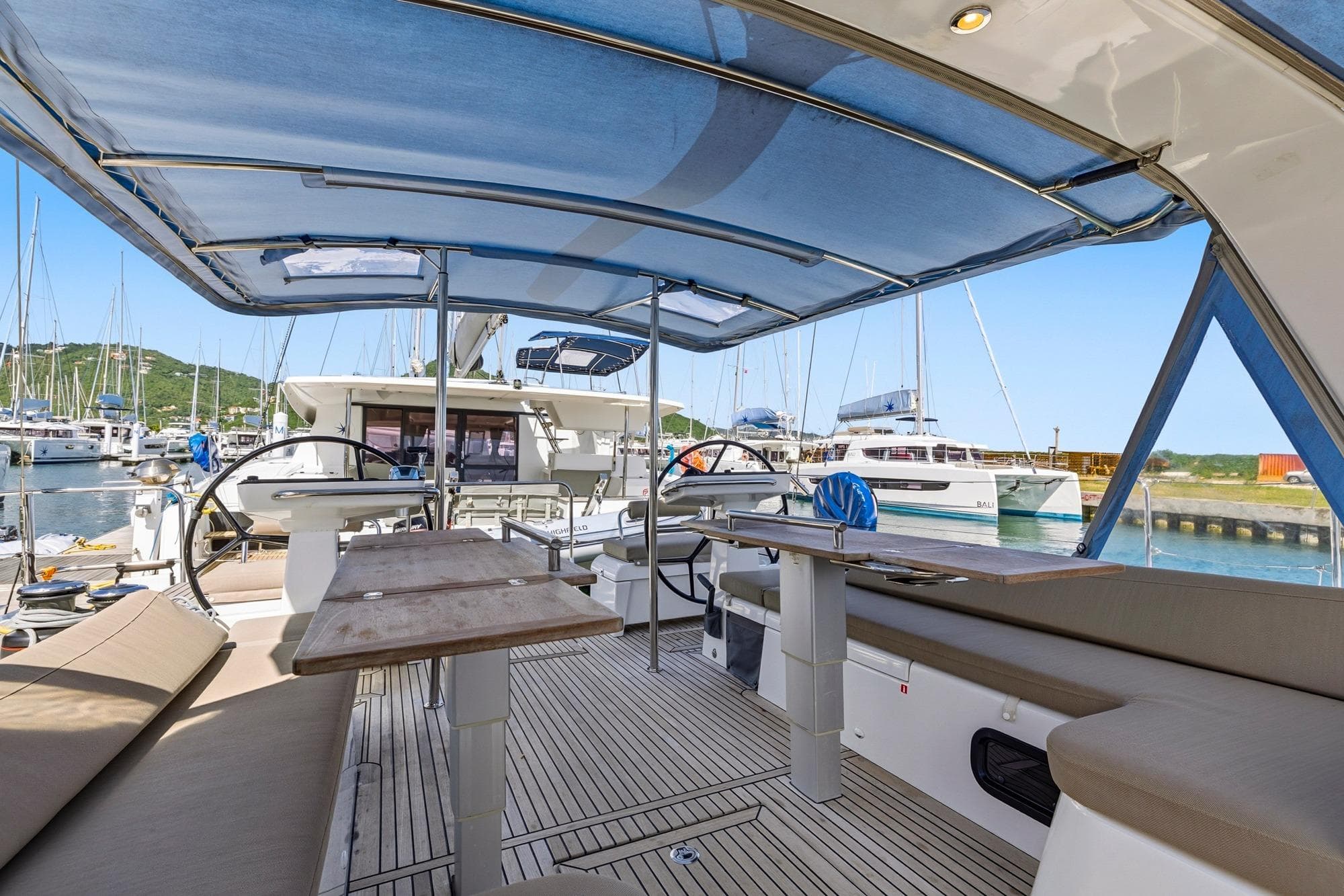 2024 Beneteau Oceanis Yacht 54 cockpit with seating, tables, and marina view.