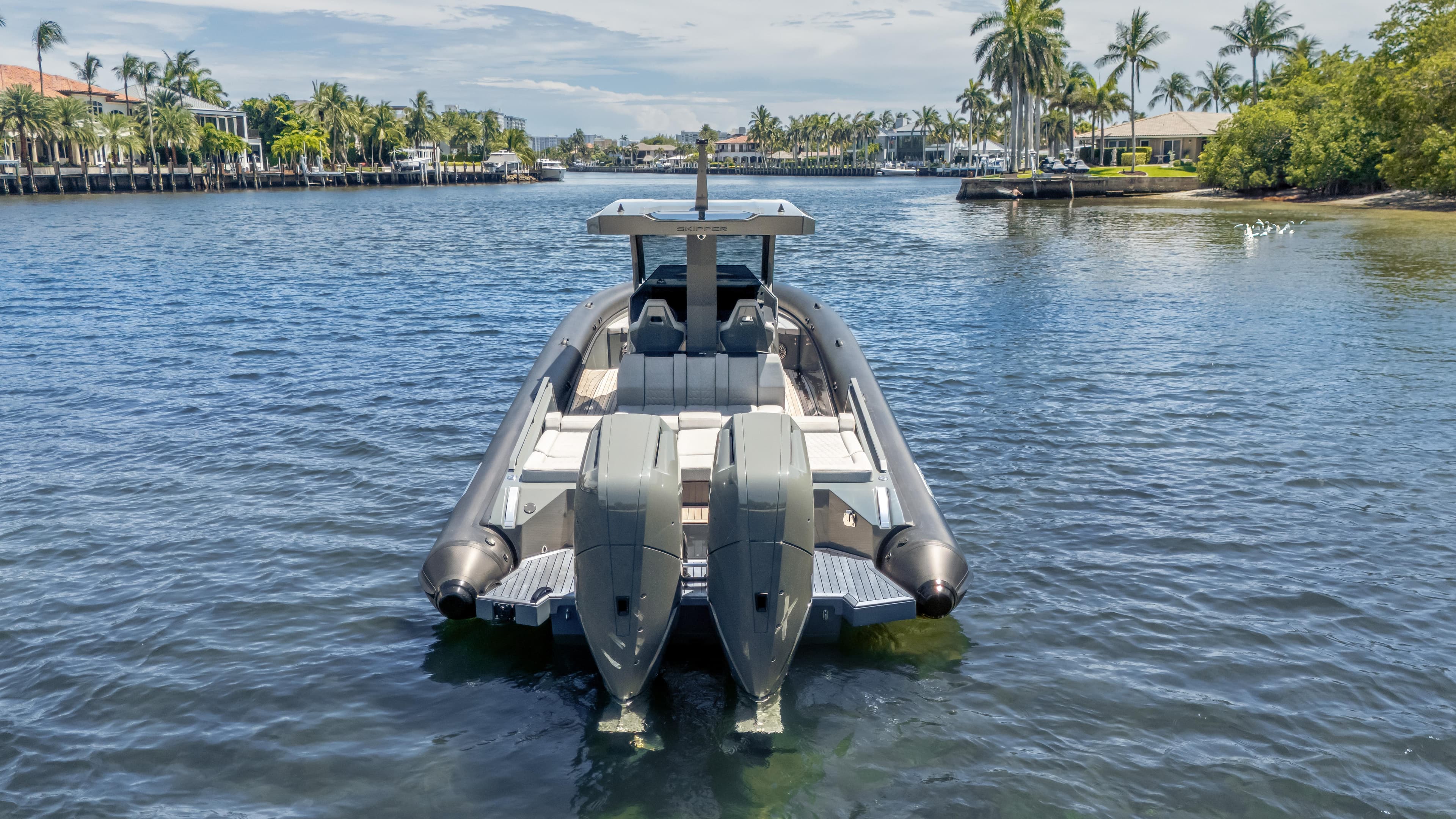 2025 Skipper-BSK 38 boat on a scenic waterway with palm trees.