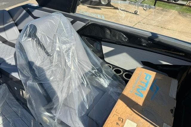 2025 Yamaha Boats 222XE interior with plastic-covered seat and cardboard box.