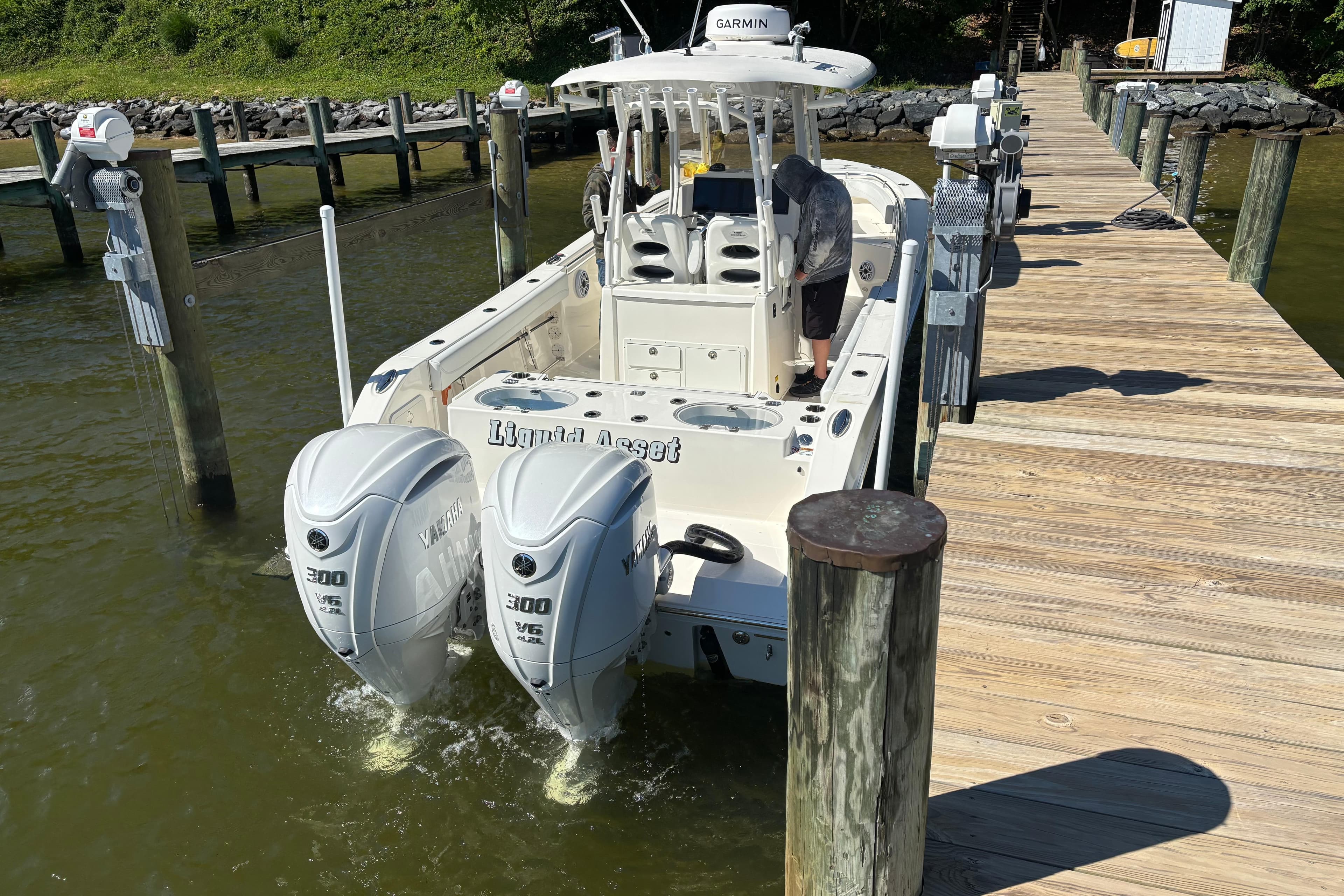 2023 Cobia 301 Center Console boat docked with twin Yamaha engines.