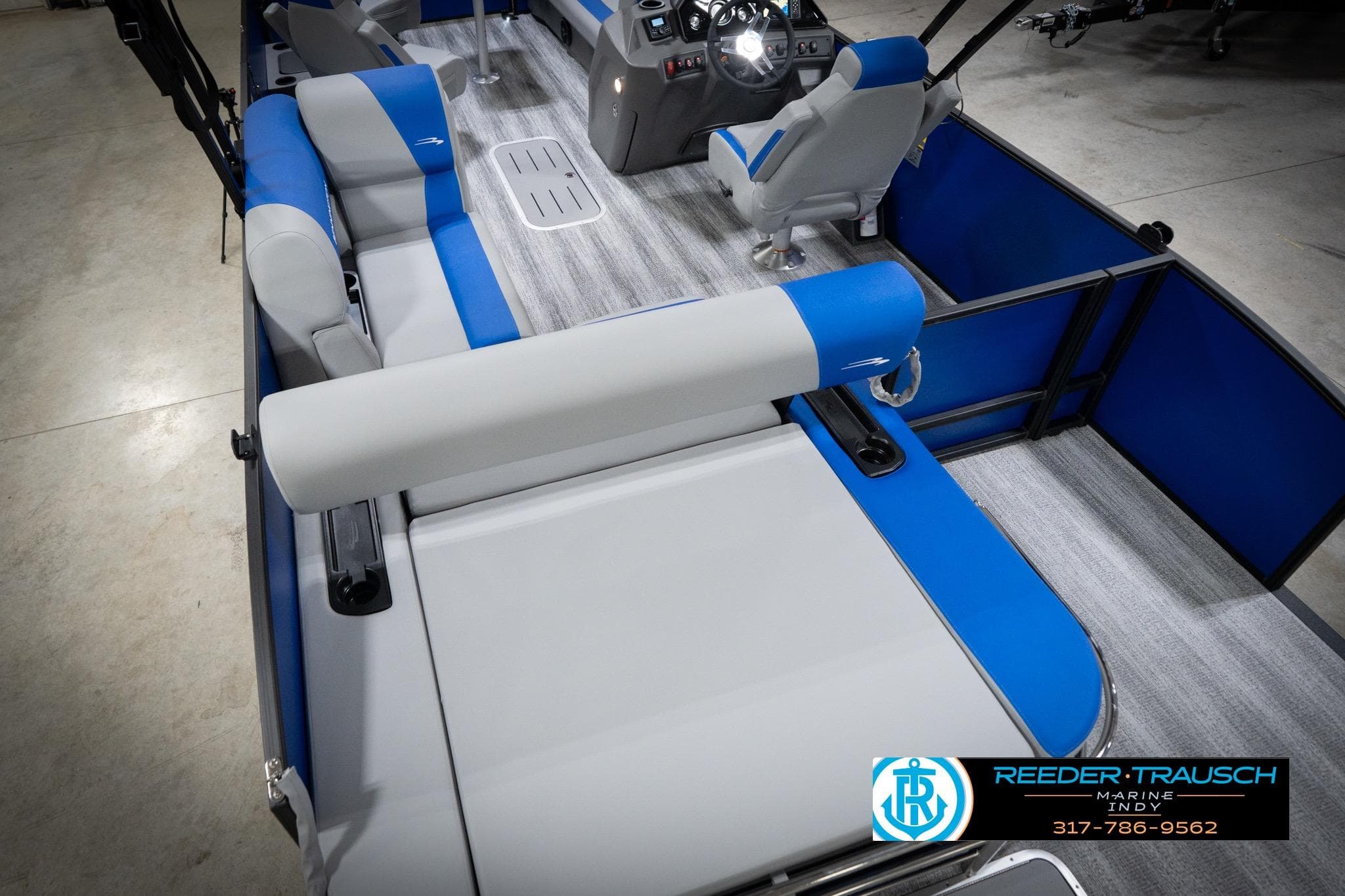 2026 Bennington 22 SSB pontoon boat interior with blue and gray seating, Reeder-Trausch Marine logo.