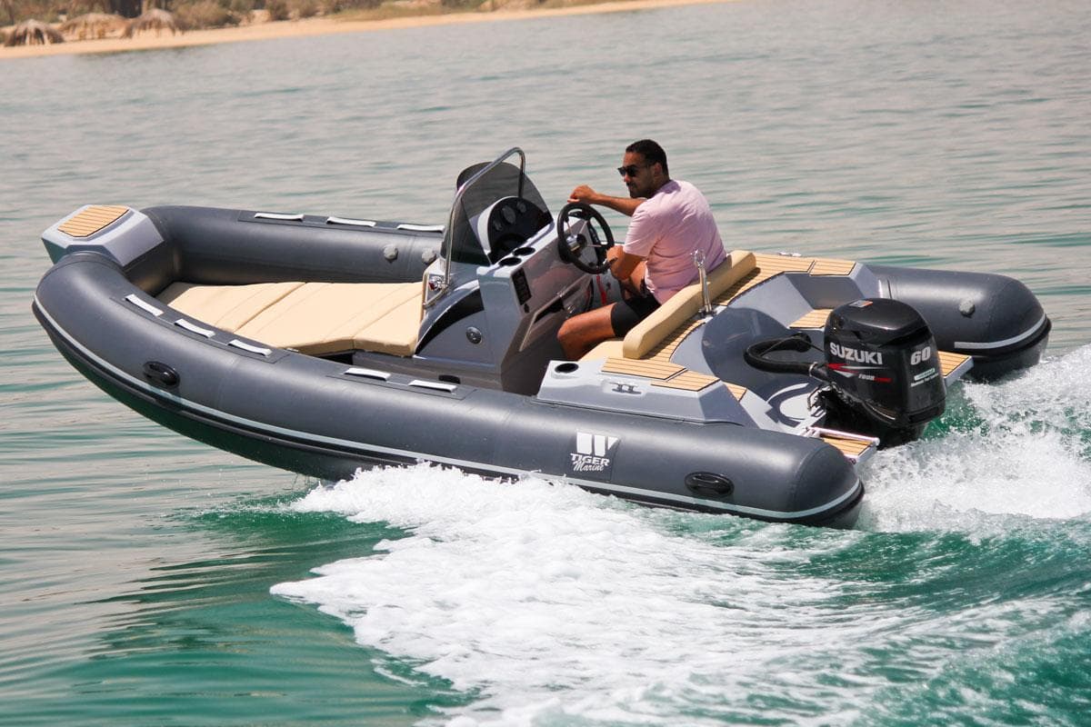 2024 Tiger Marine SL 480 inflatable boat cruising on water with Suzuki outboard motor.