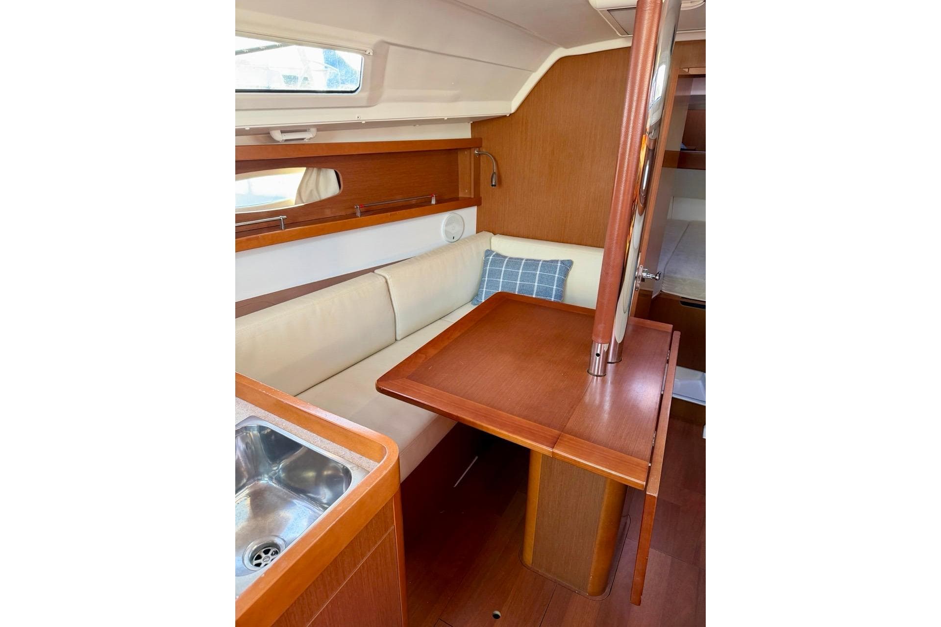 2014 Beneteau Oceanis 31 interior with wooden dining area and cozy seating.