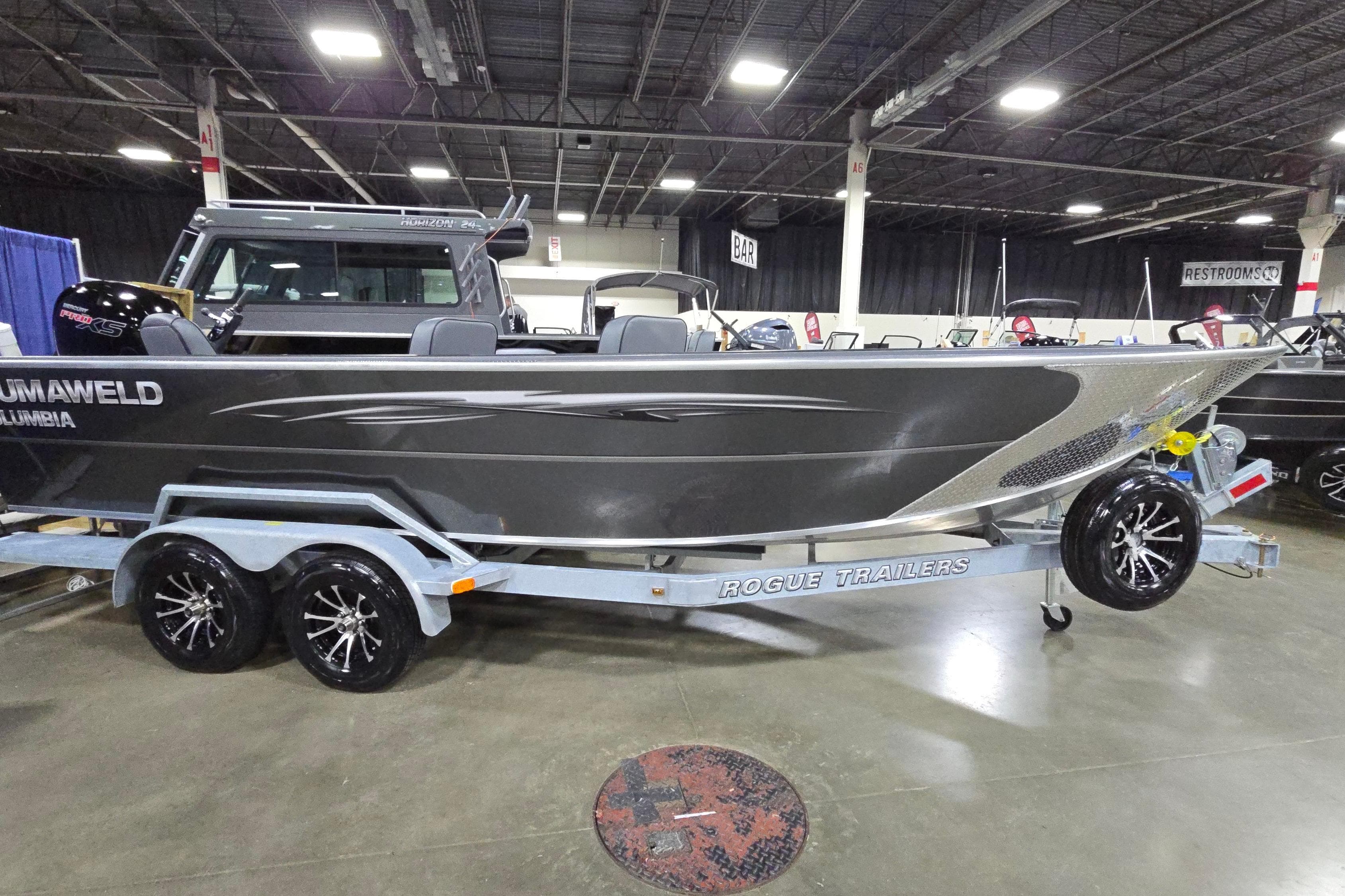 2026 Alumaweld Columbia 21 boat on Rogue trailer at indoor exhibition.