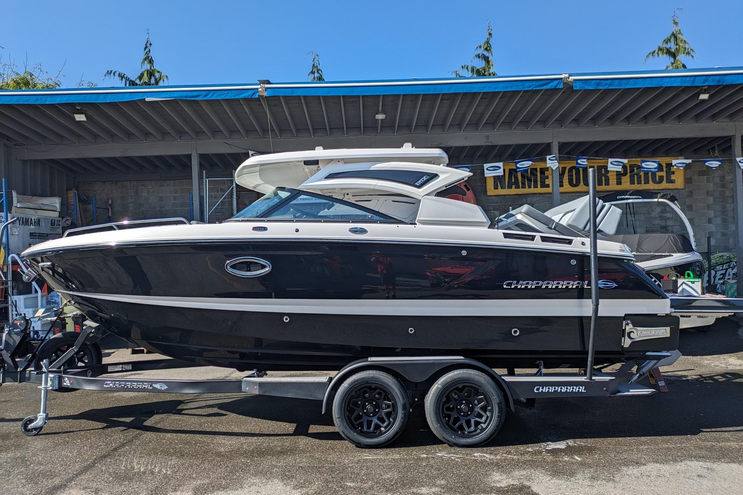 2026 Chaparral 6 GTS boat on trailer, displayed outdoors under a canopy.