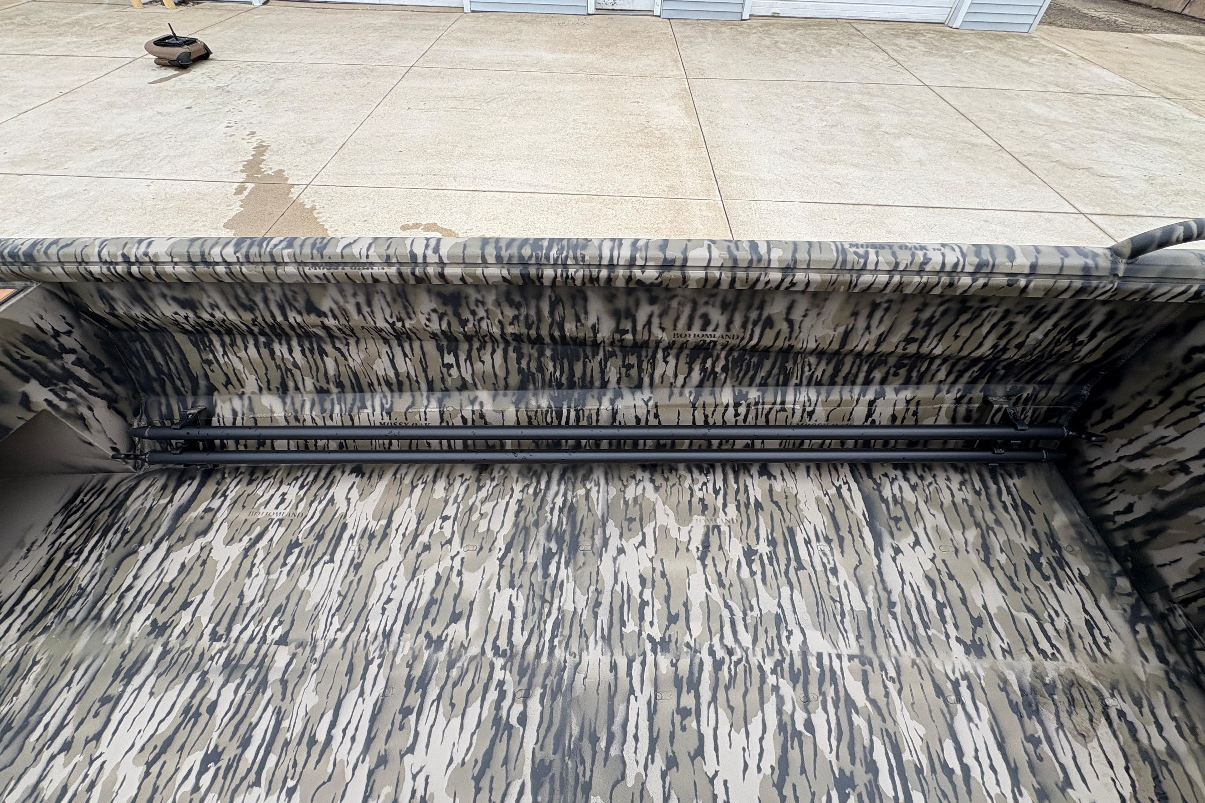 Camouflage interior of 2026 Excel 1860 F4 Pro boat on concrete surface.