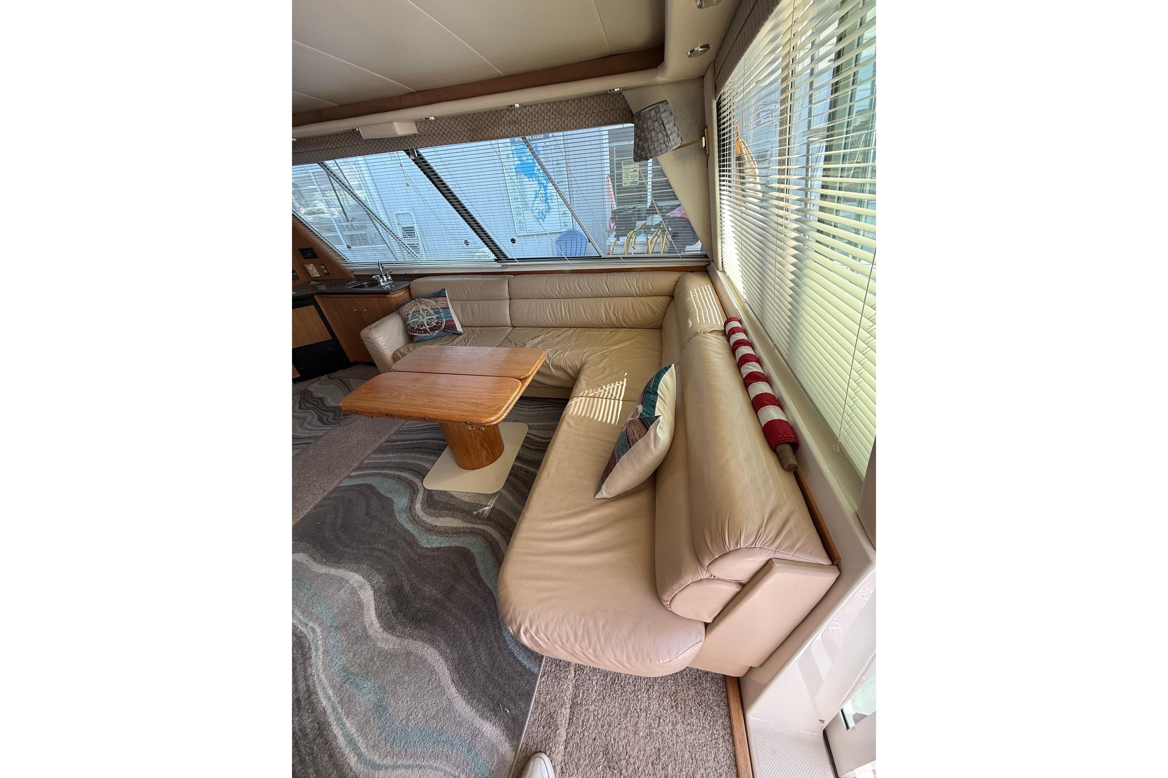 Luxurious interior of 1997 Bayliner 47 Motoryacht with leather seating and wooden table.