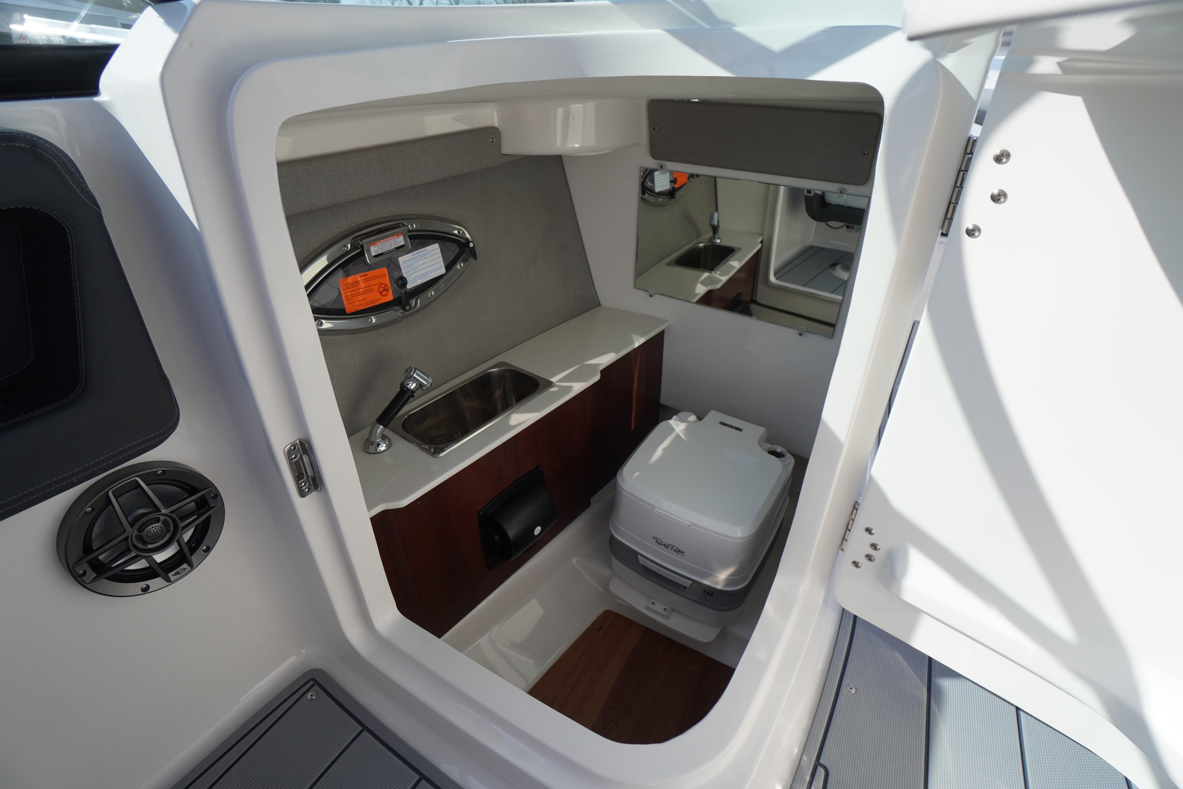 Interior of 2026 Chaparral 250 OSX boat featuring compact bathroom amenities.