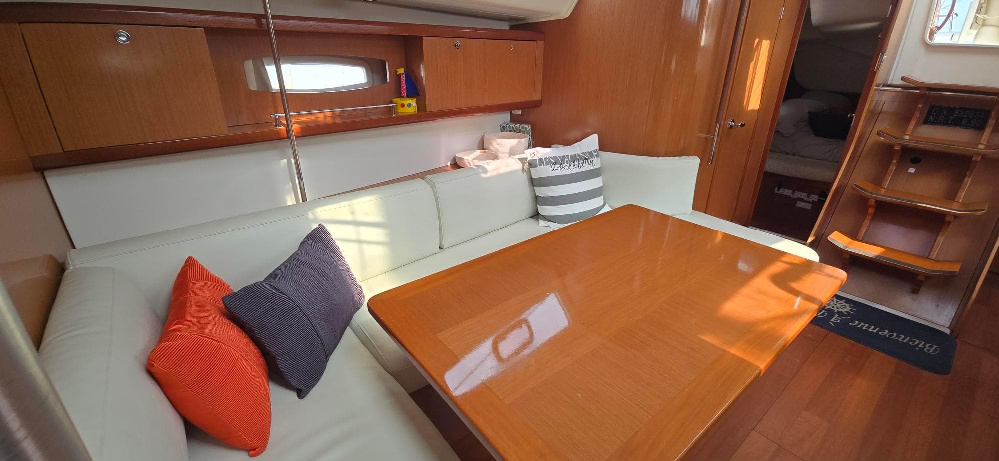 Interior of 2008 Beneteau Oceanis 40 yacht with cozy seating and wooden table.