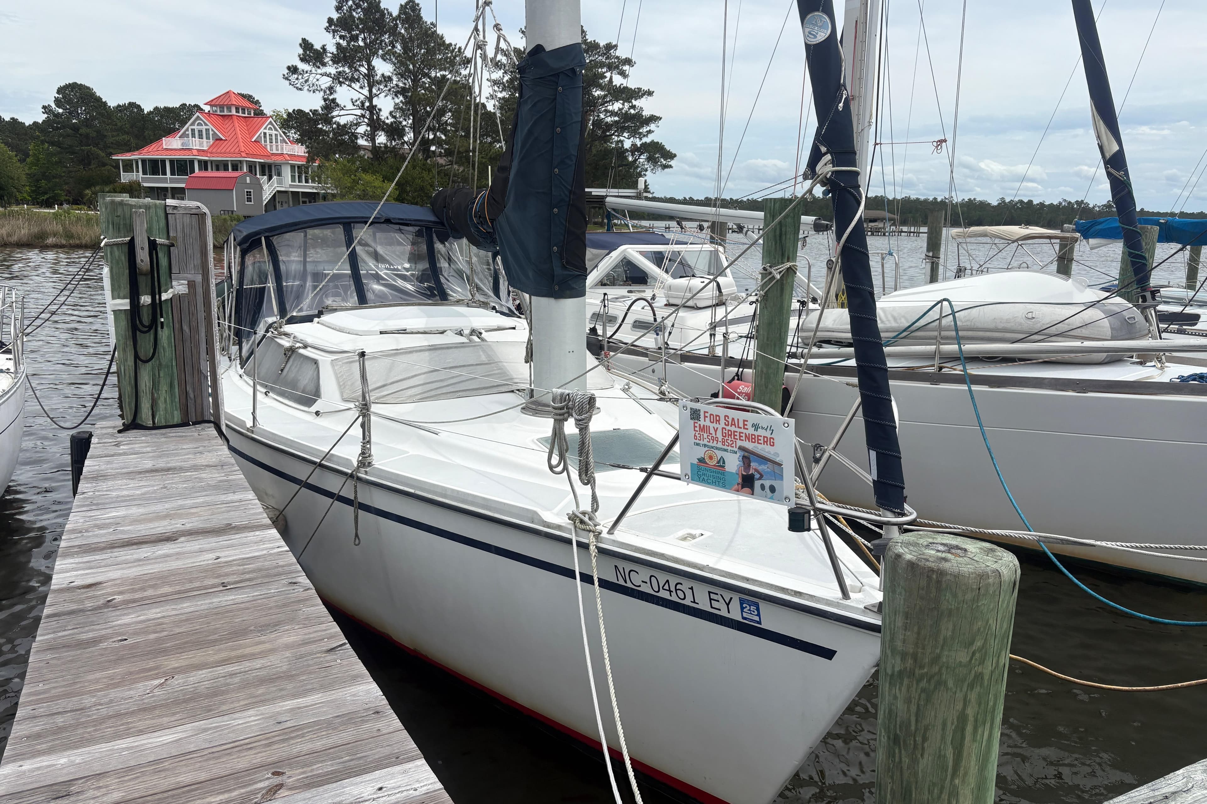 Sailboat Hunter Vision 32, 1989 model, docked with a "For Sale" sign.