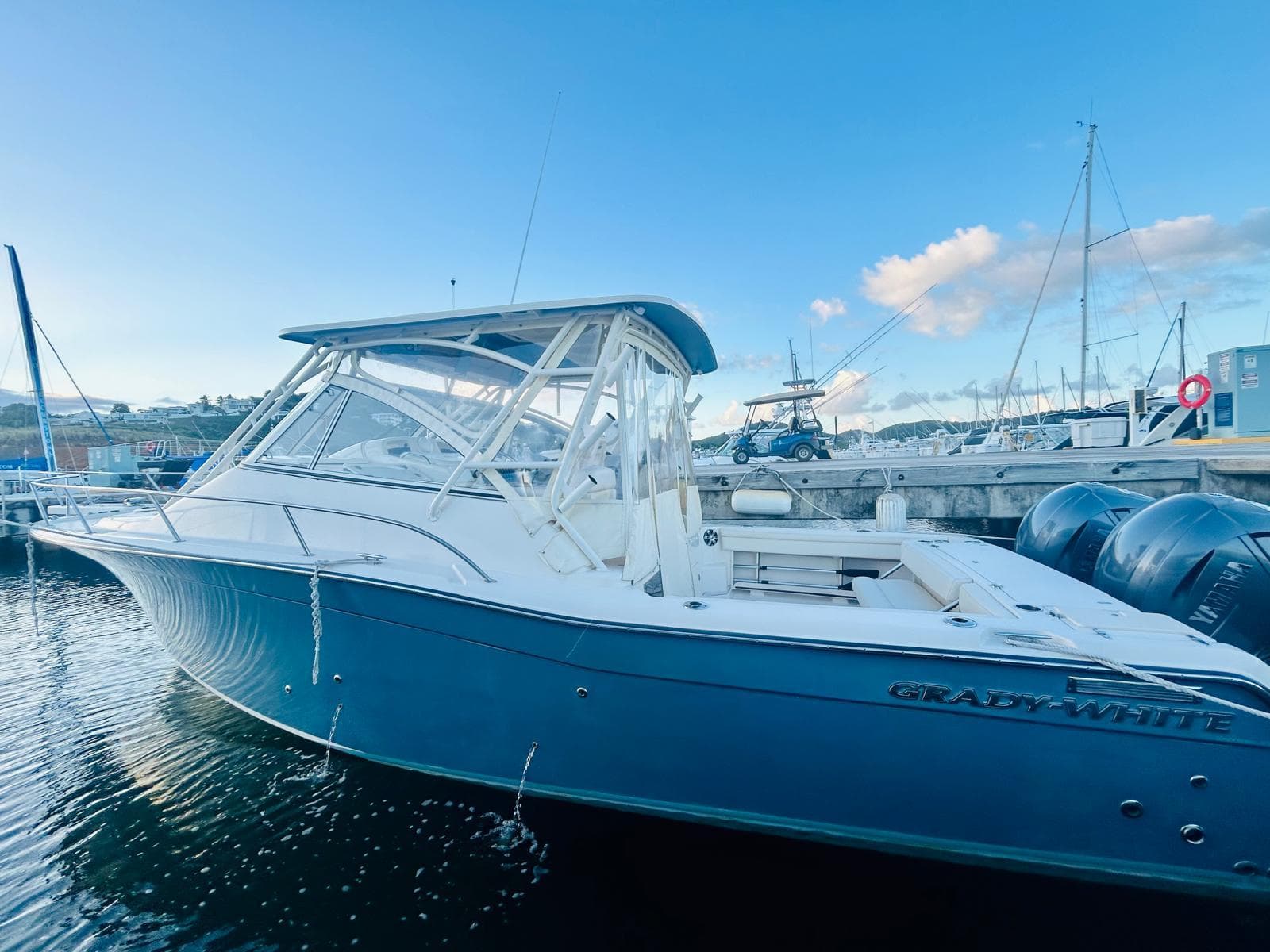 2021 Grady-White Express 330 boat docked in marina under clear blue sky.