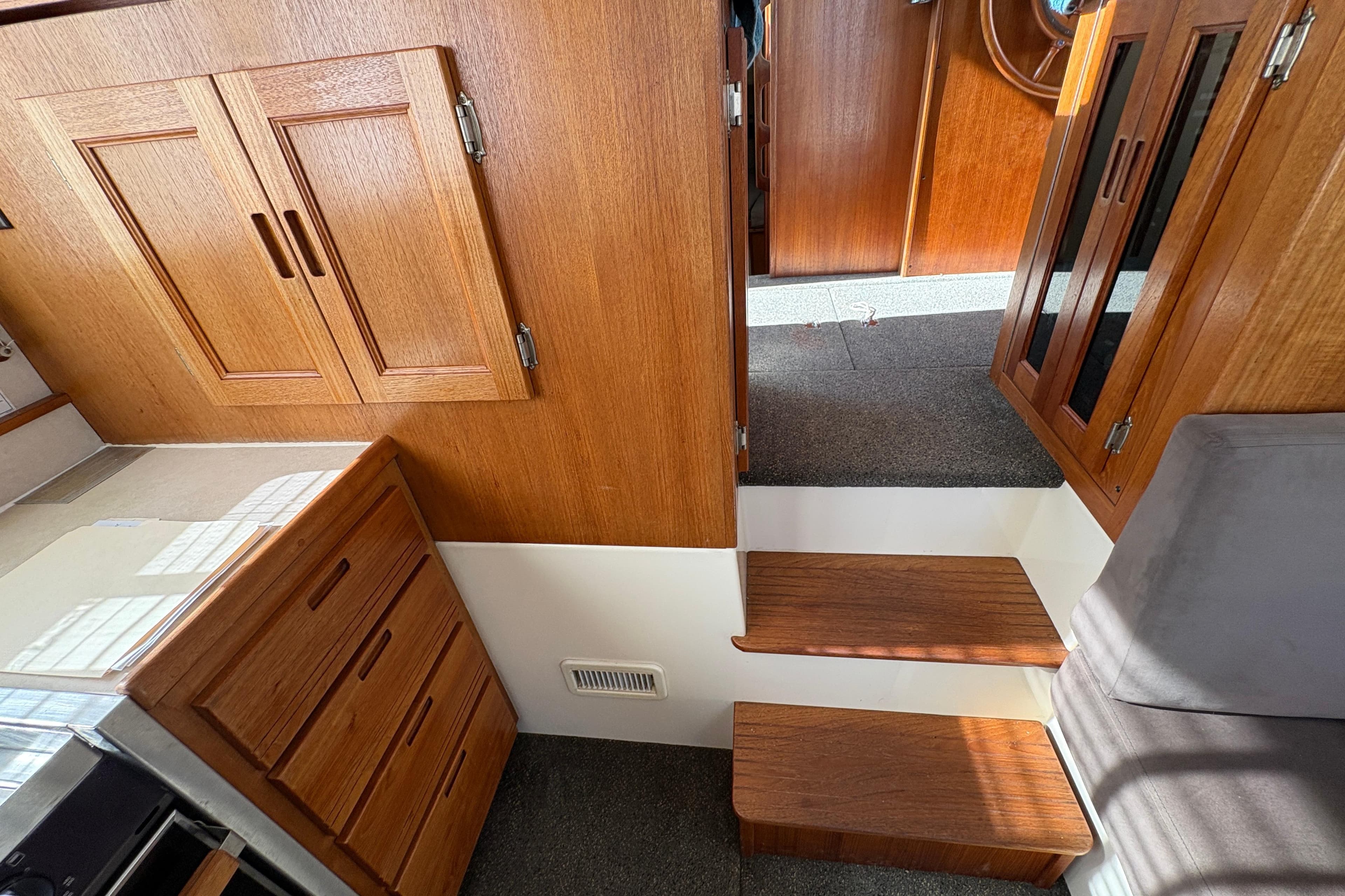 Interior of 2004 Nordic Tug 32, featuring wooden cabinetry and carpeted steps.