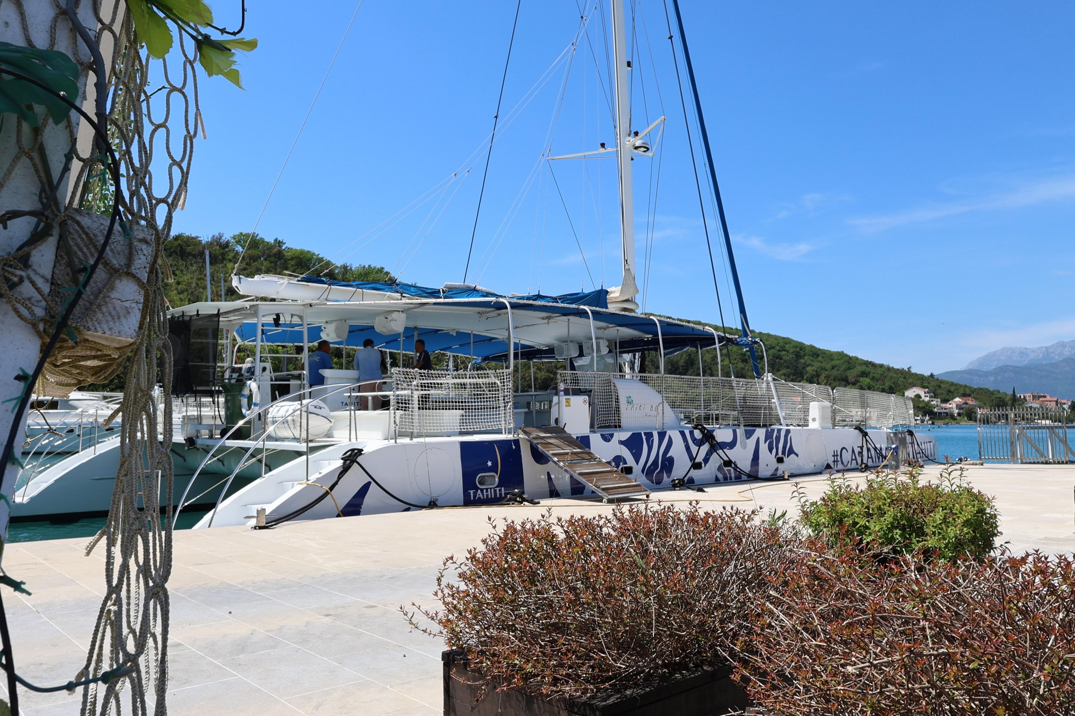 2015 Fountaine Pajot Taiti Day Charter 80 catamaran docked by scenic waterfront.