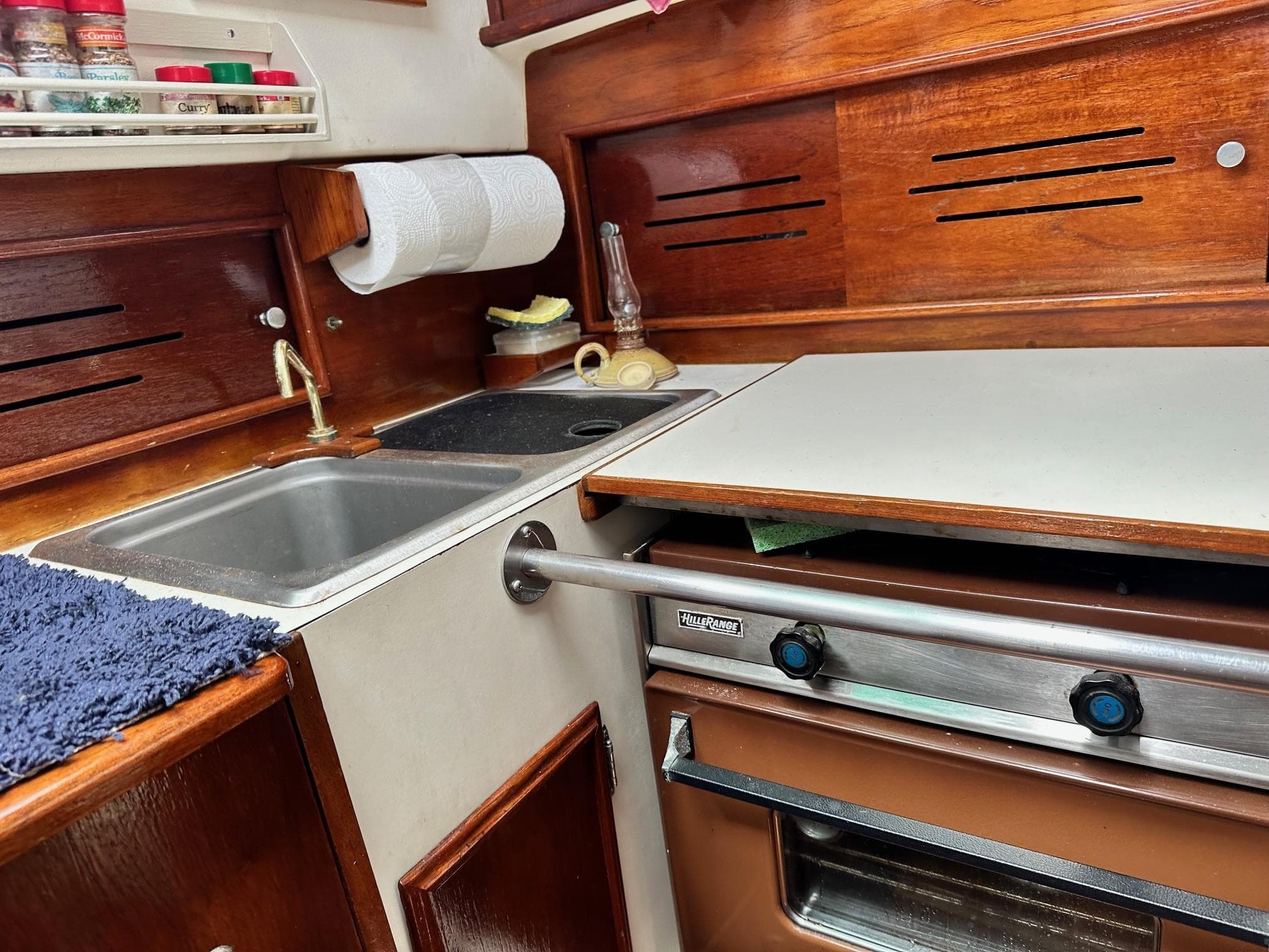 1982 Cape Dory 30 sailboat galley with sink, stove, and spice rack.