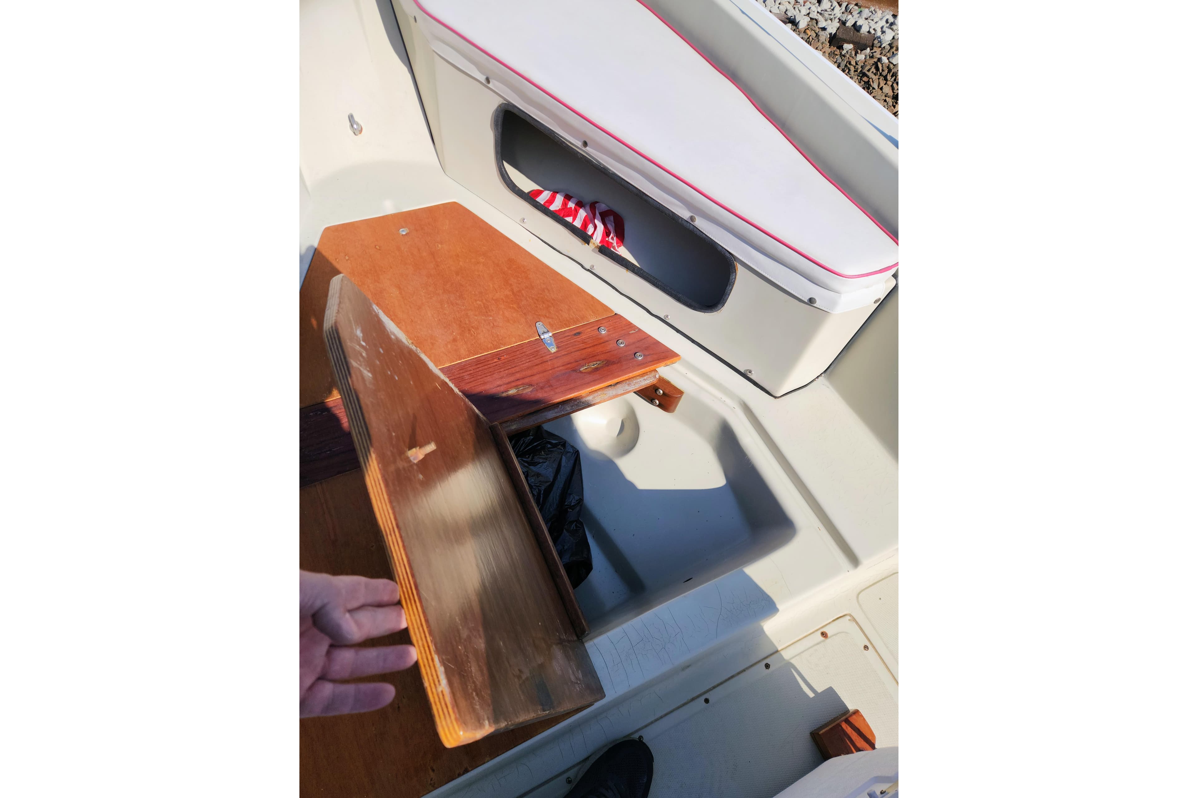 1978 Boston Whaler Outrage 20 interior with wooden storage compartment and cushioned seating.