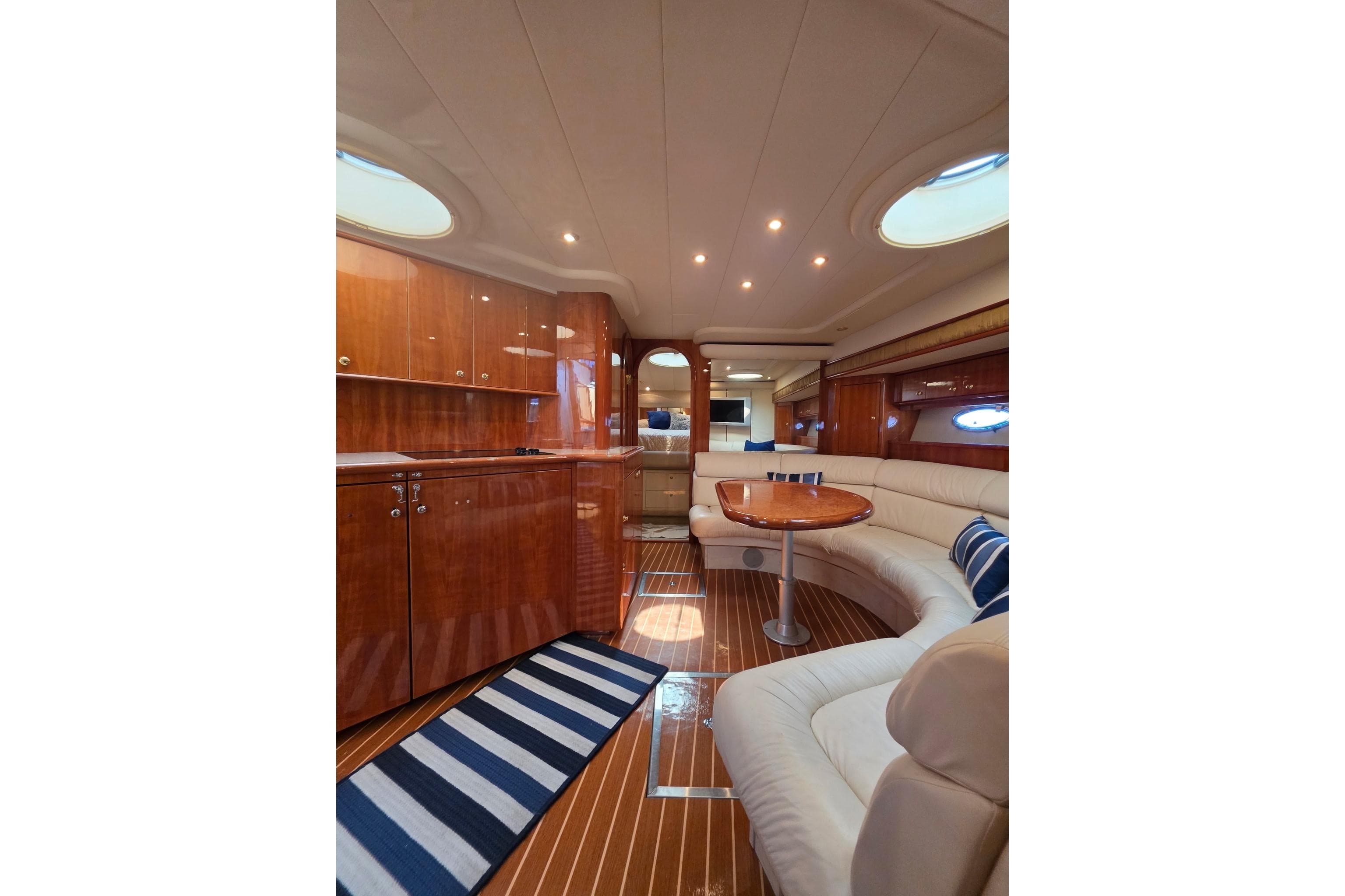 Luxurious interior of 2000 Neptunus 56 Express yacht with elegant wood finishes and plush seating.