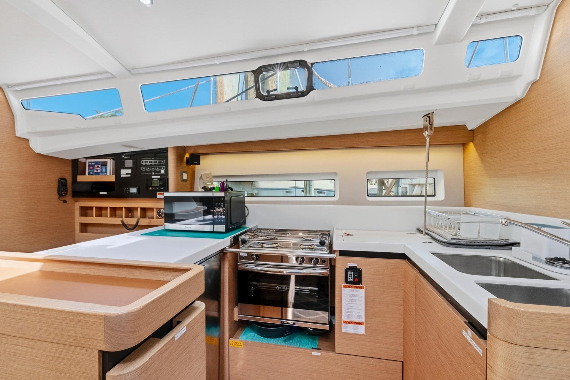 Modern kitchen interior of 2021 Jeanneau Sun Odyssey 440 yacht with sleek design and appliances.