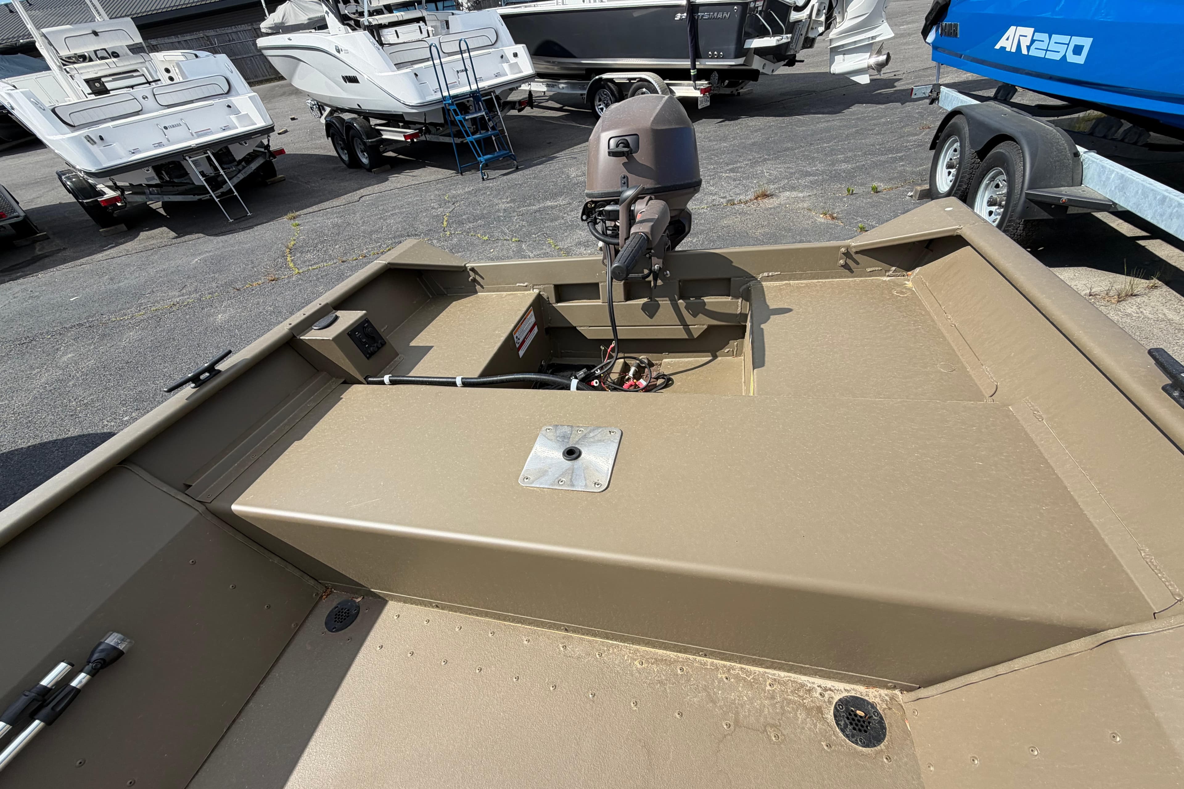 2026 G3 Gator Tough Package Jon 15 FL boat, tan interior, outboard motor, parked among other boats.