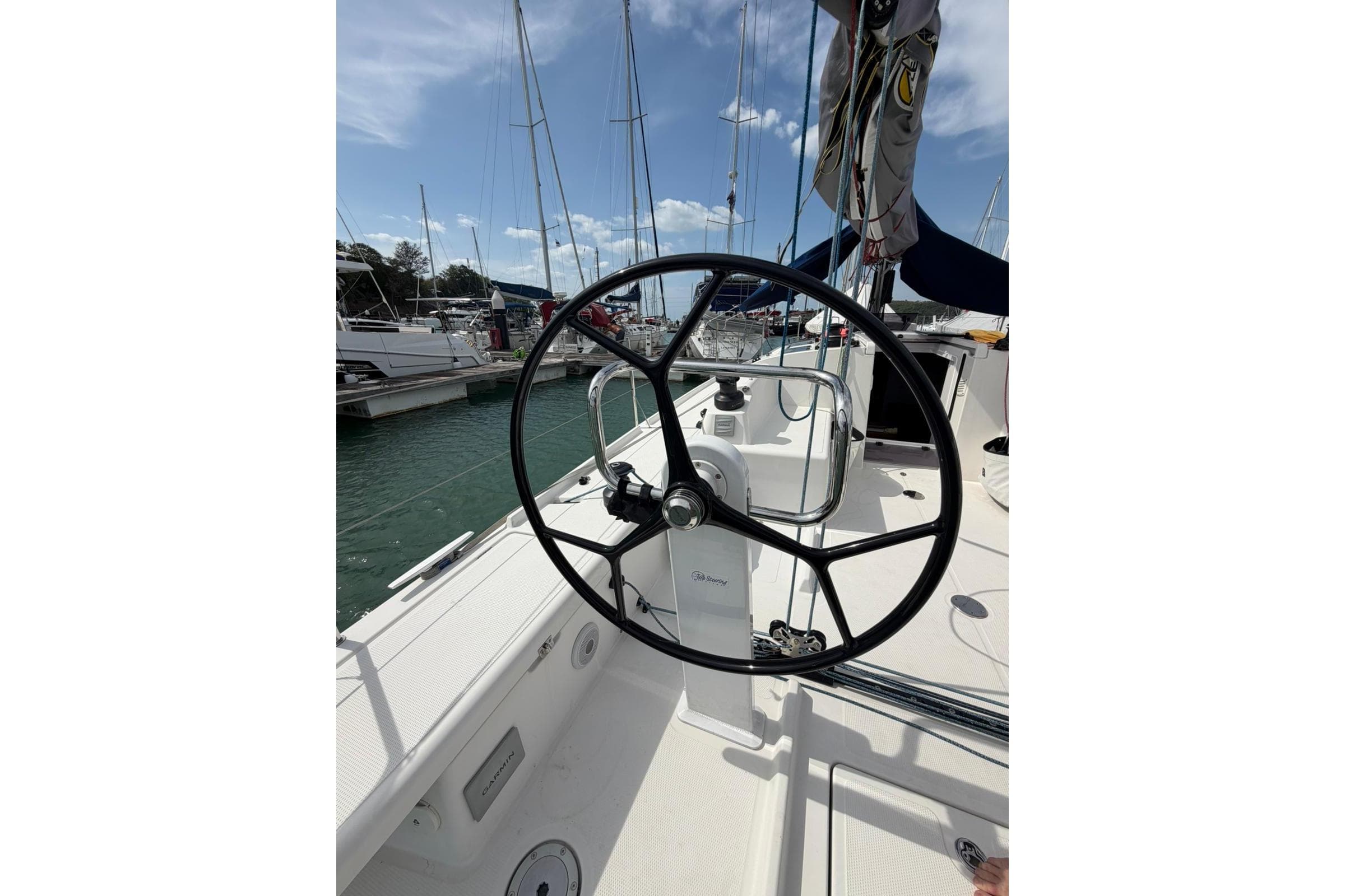 2023 Beneteau First 36 sailboat cockpit with steering wheel, docked at marina.