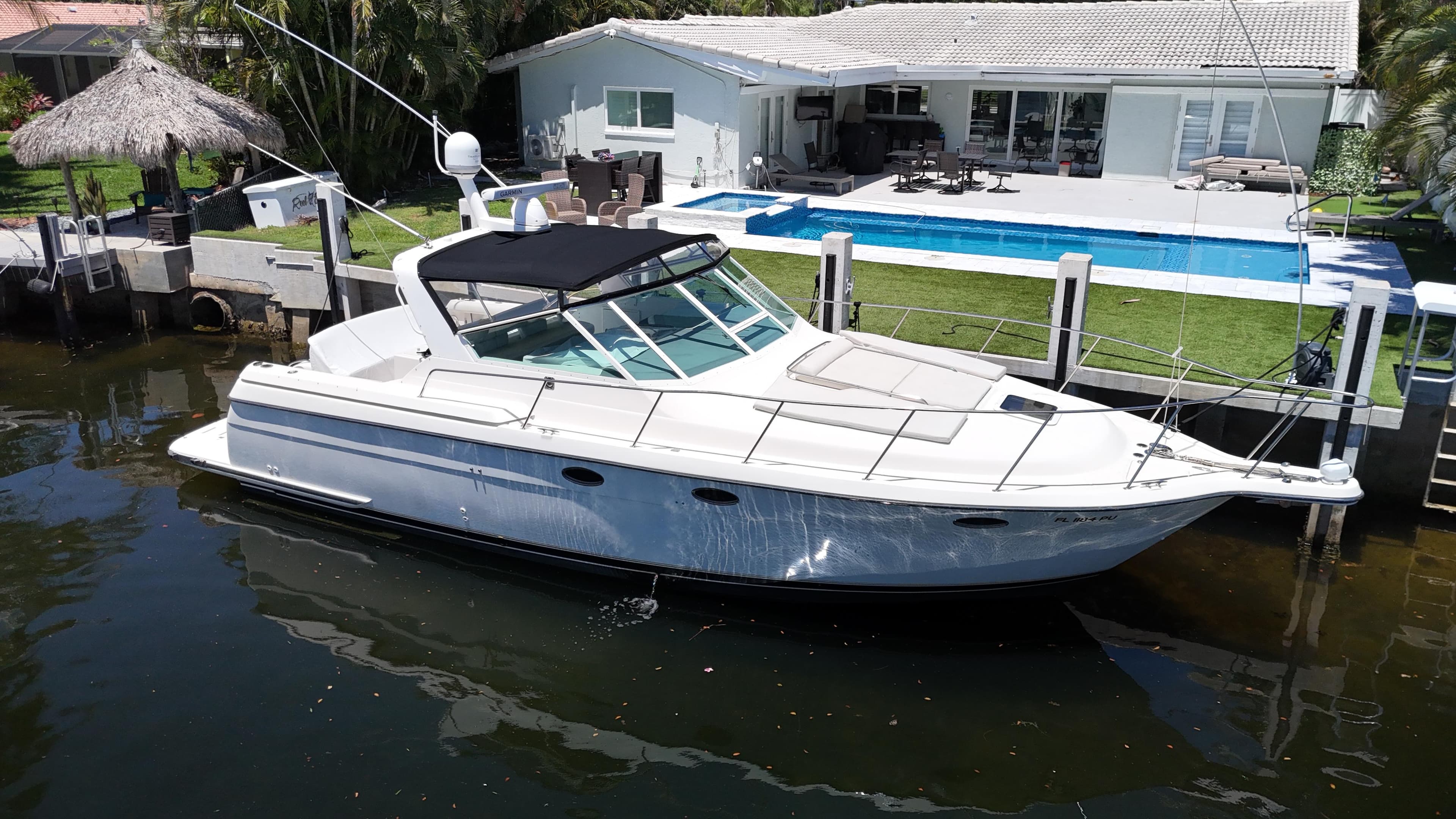 1998 Tiara Yachts 3500 Express docked near a modern waterfront home.