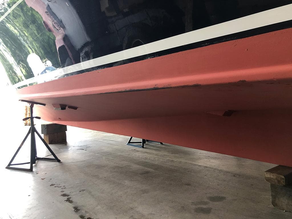 1999 Fortier 26 boat hull on stands in a workshop.