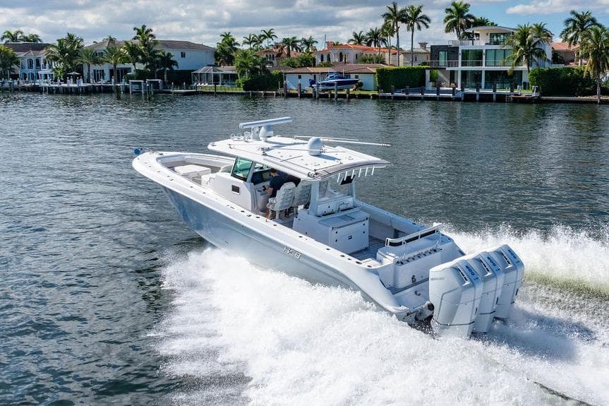 2024 HCB 42 Lujo boat cruising on a scenic waterway with palm trees.