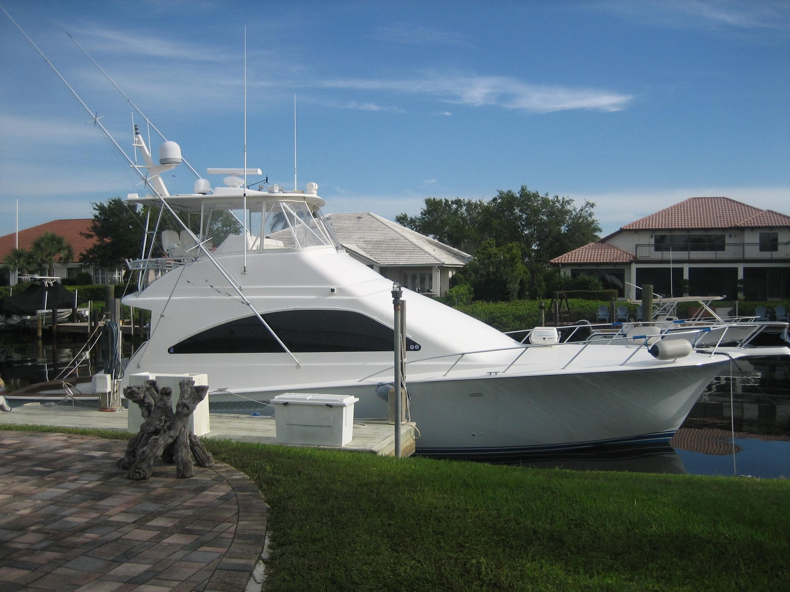 2005 Ocean Yachts 50 Super Sport docked near waterfront homes.