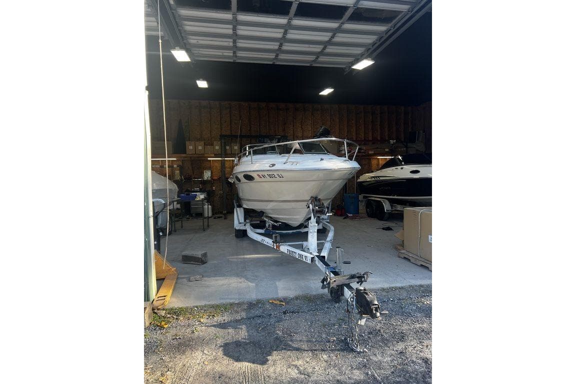 1994 Sea Ray 220 boat on trailer inside a garage, ready for transport.