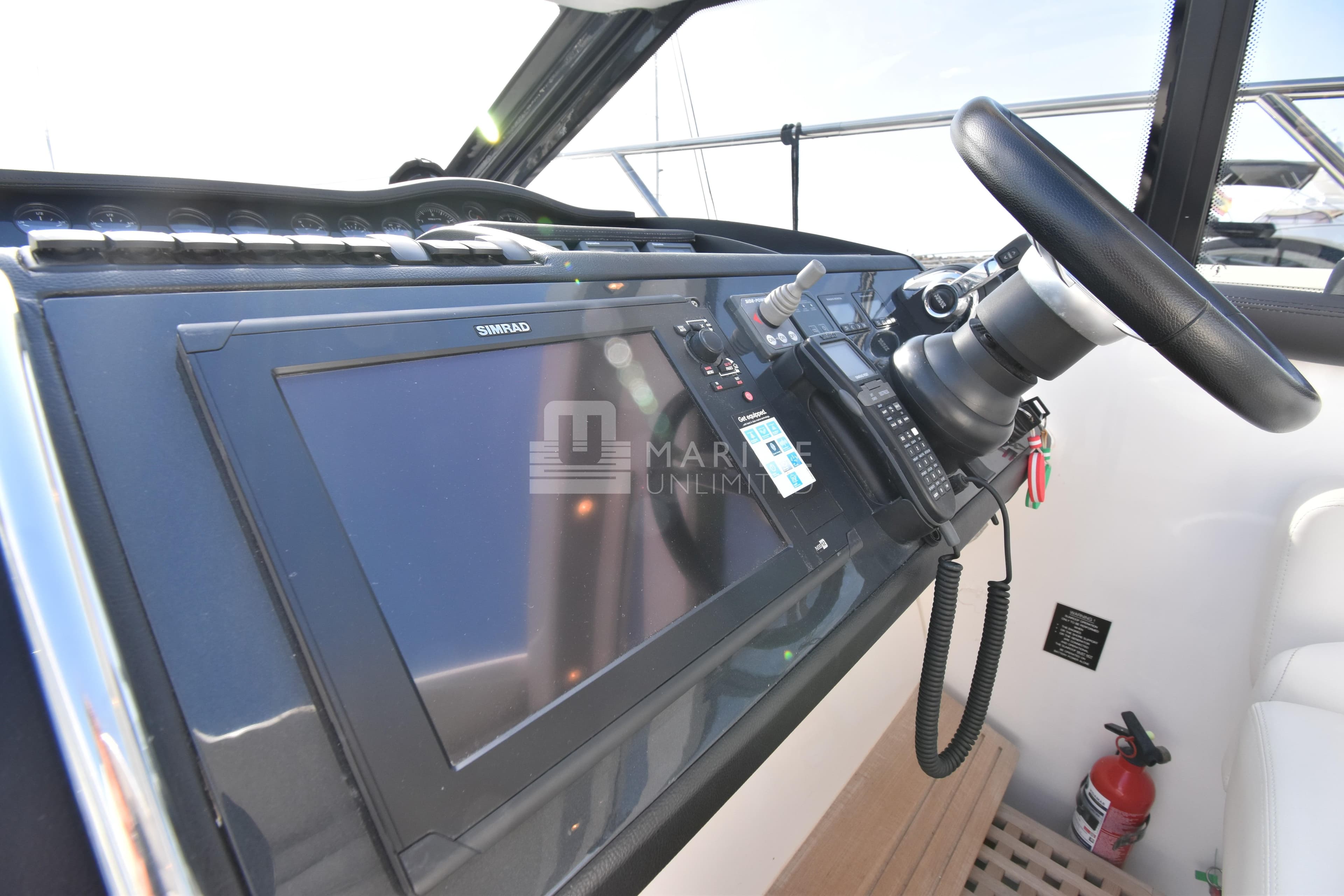 Helm of 2012 Princess V42 yacht with Simrad navigation system and steering wheel.