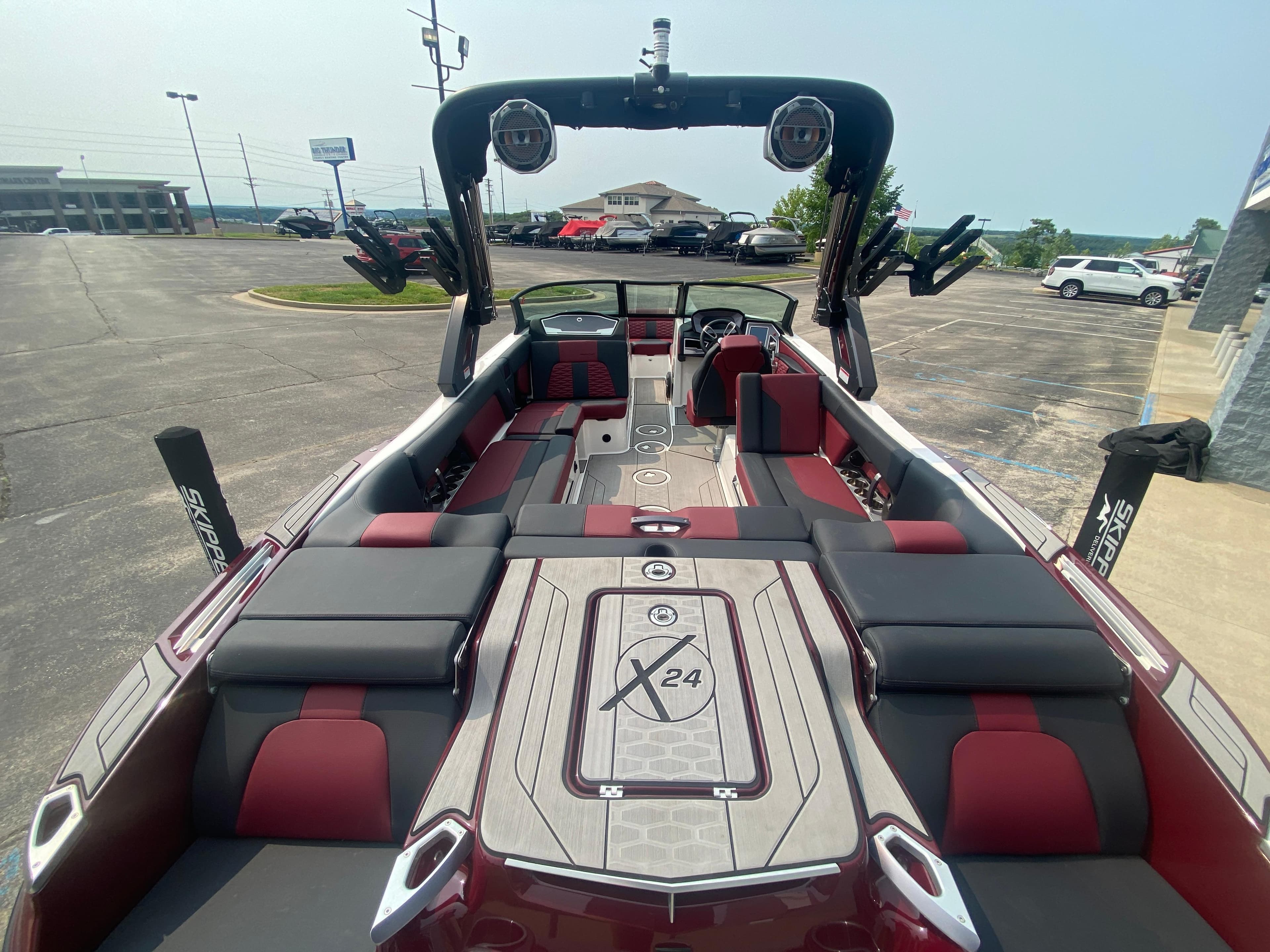 2022 MasterCraft X24 boat interior with red and gray seating, parked in a lot.