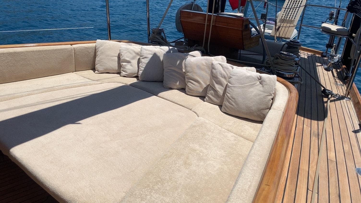 Luxurious yacht deck with beige cushions, Custom LEVANTINA 2003, sailing on blue ocean waters.