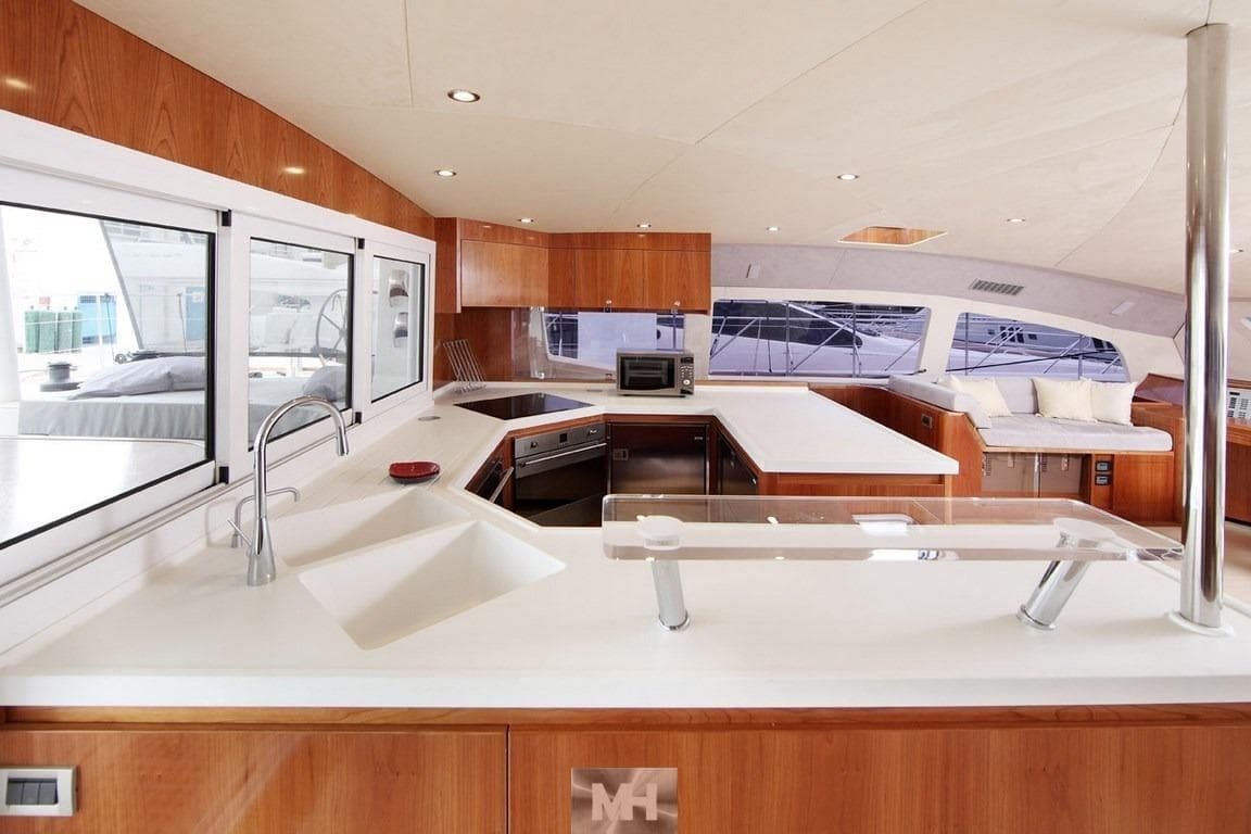 Luxurious Catana 85 yacht interior with modern kitchen and seating area, 2010 model.