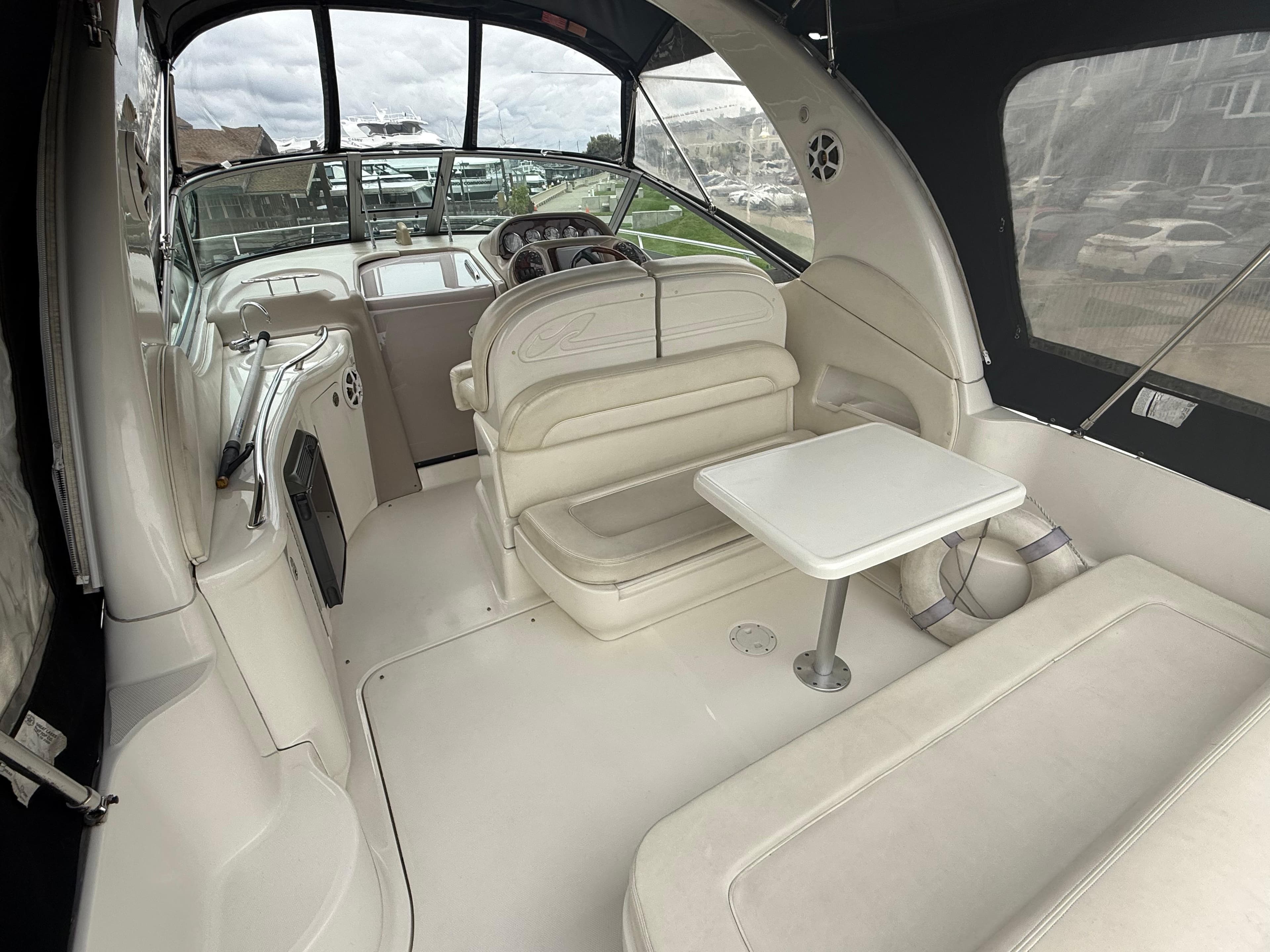 2004 Sea Ray 300 Sundancer interior with seating and table, showcasing luxury boat design.